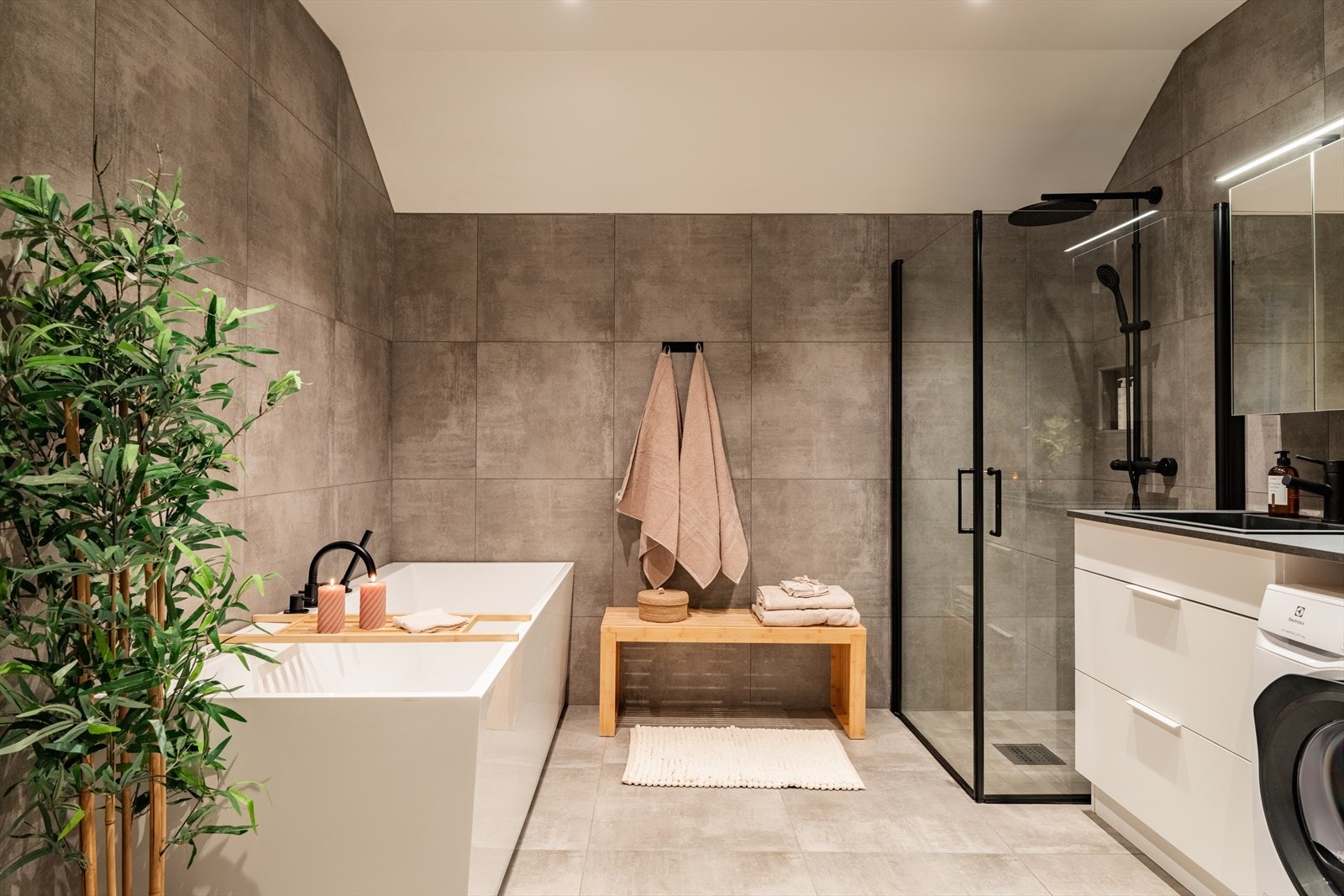 Stort og moderne familiebad med frittstående badekar, walk-in dusj, innredning fra KVIK og store fliser fra Flisekompaniet. Varme i gulv. Galleribilde