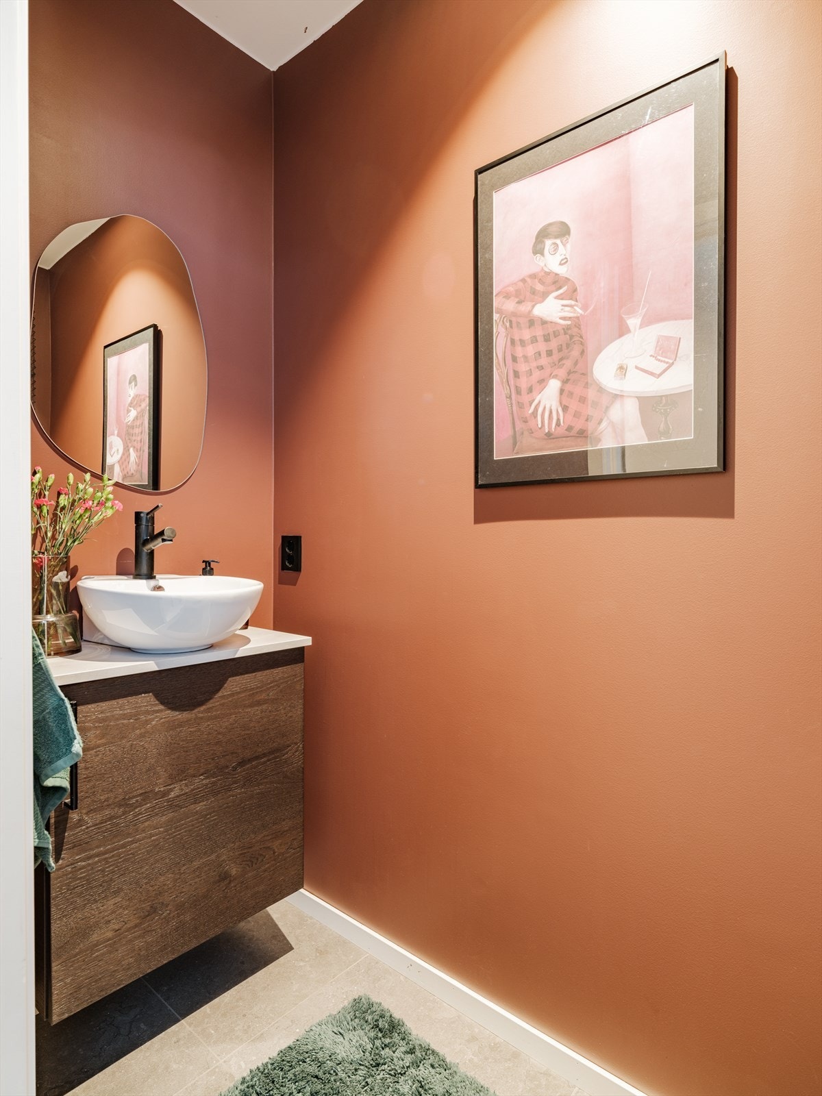 Et elegant gjestebad med dristig, varm terrakottafarge (Sophisticated red fra Jotun 2025). Innredning fra KVIK, svarte detaljer og fliser fra Flisekompaniet gir et moderne og helhetlig uttrykk. Galleribilde