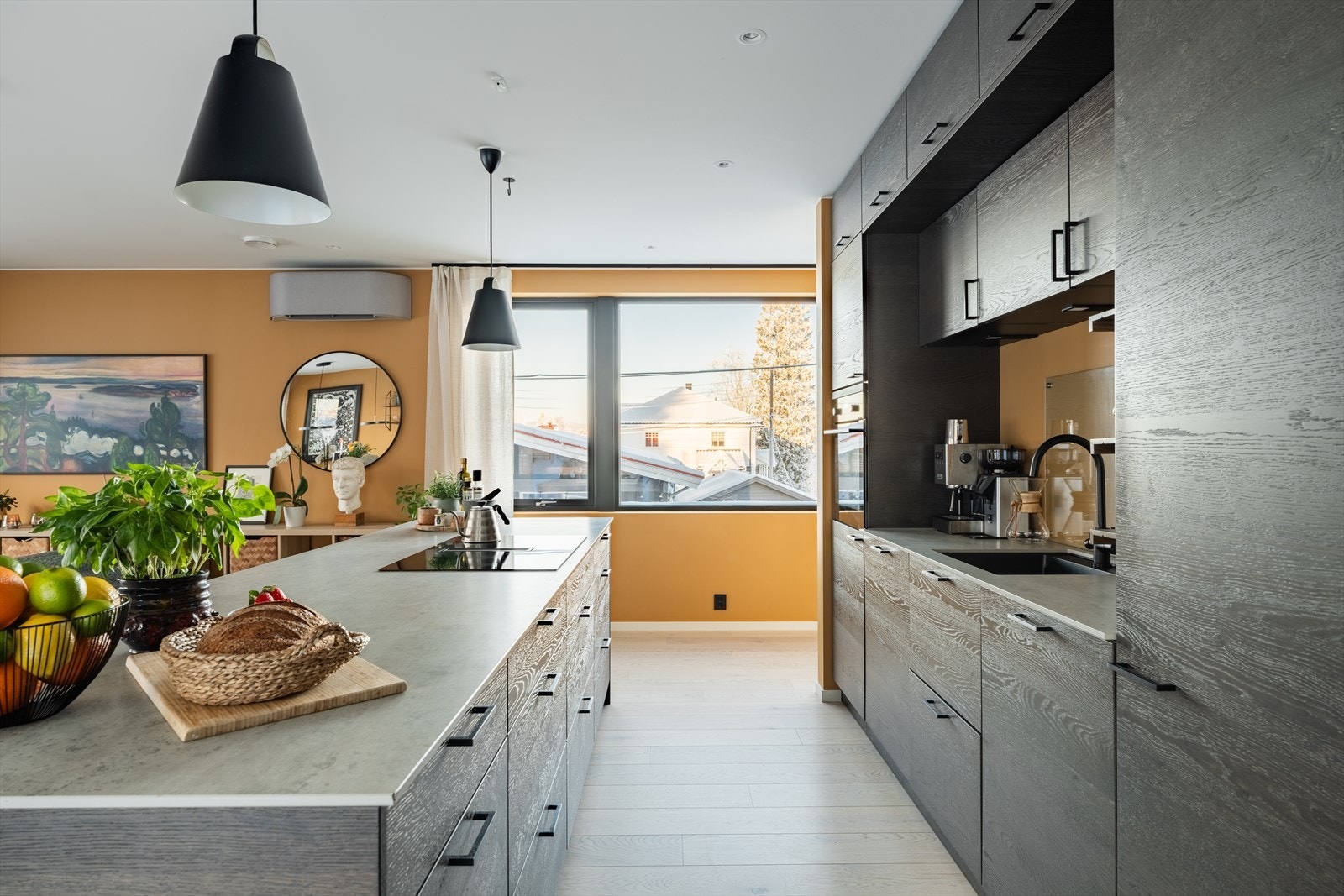 Den nedfelte ventilasjonsløsningen gir åpne linjer og et minimalistisk uttrykk. God arbeidsplass, rikelig lagring og en gjennomtenkt lysplan gjør dette til et kjøkken for både hverdagsmat og større selskap. Galleribilde