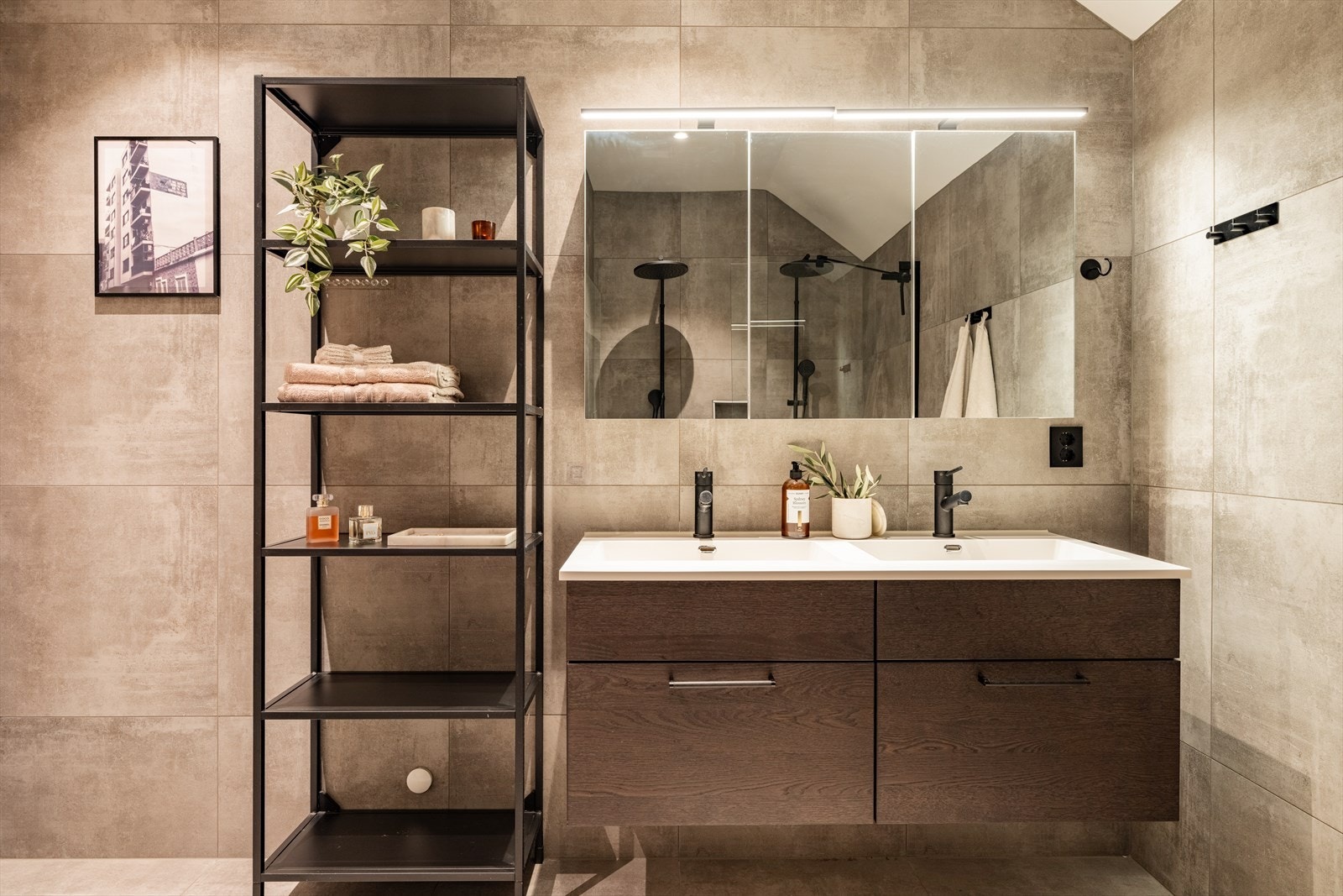 Luksuriøst masterbad med dobbel servant. Svart armatur og store fliser fra gulv til tak. Direkte adkomst fra soverommet gir en suite-følelse som gjør morgenene litt bedre. Galleribilde