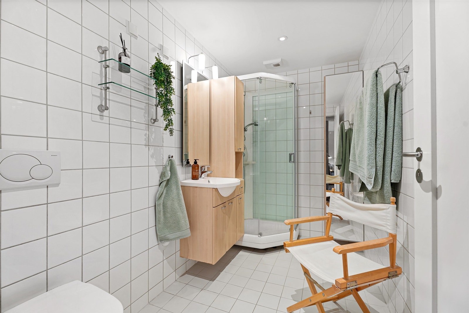 Flislagt baderom med vegghengt toalett, spotter i himling og vannbåren gulvvarme (Opplegg for vaskemaskin både her og i innvendig bod med "waterguard" Galleribilde