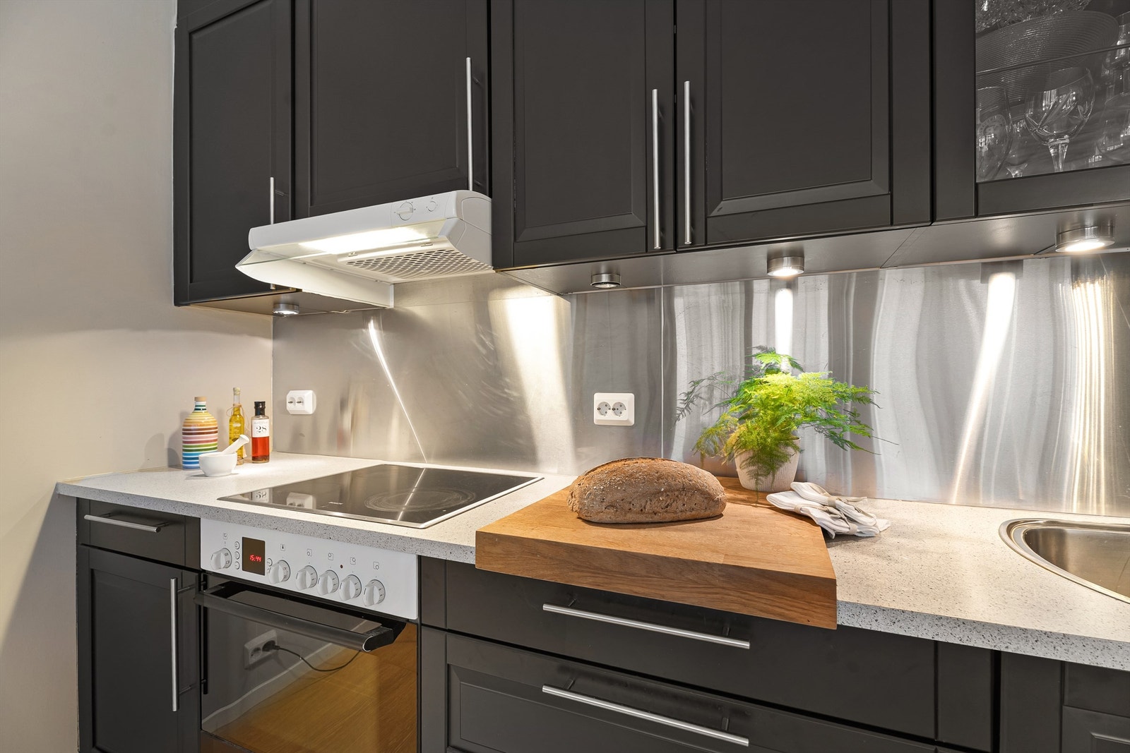 Integrerte hvitevarer - Sort kjøkken oppusset i senere tid med godt med skap -og benkeplass Galleribilde