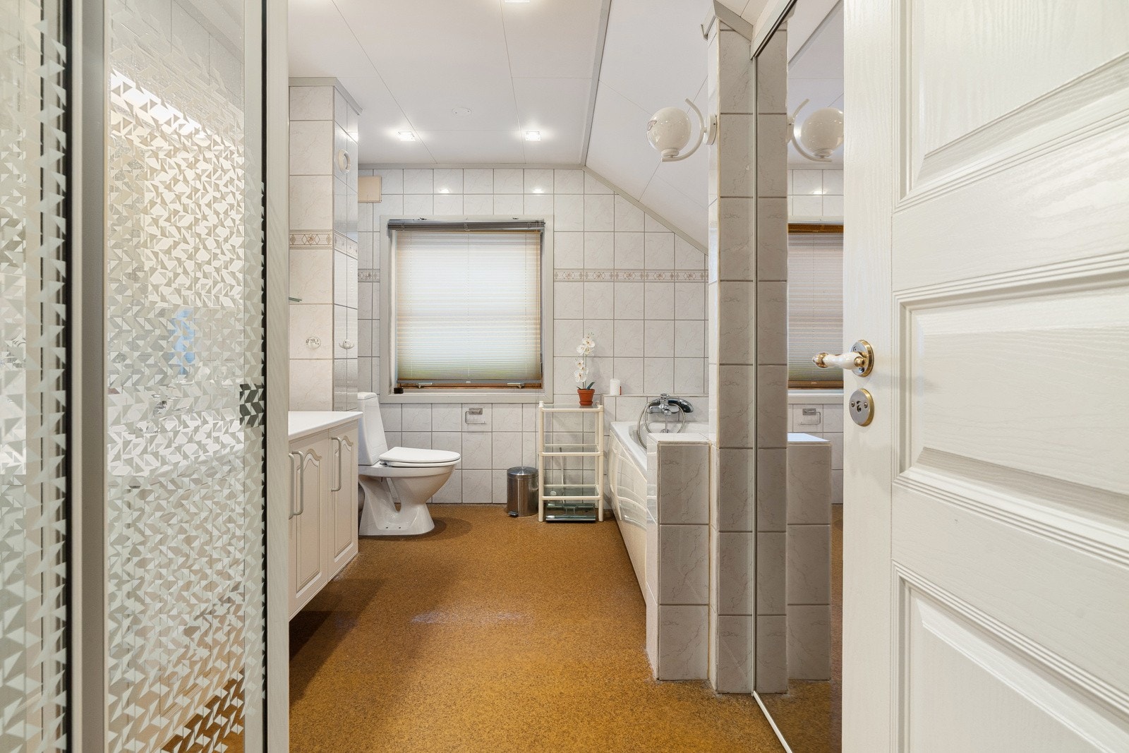 Baet har wc, praktisk baderomsinnredning med servant, speil og downlights i himling Galleribilde