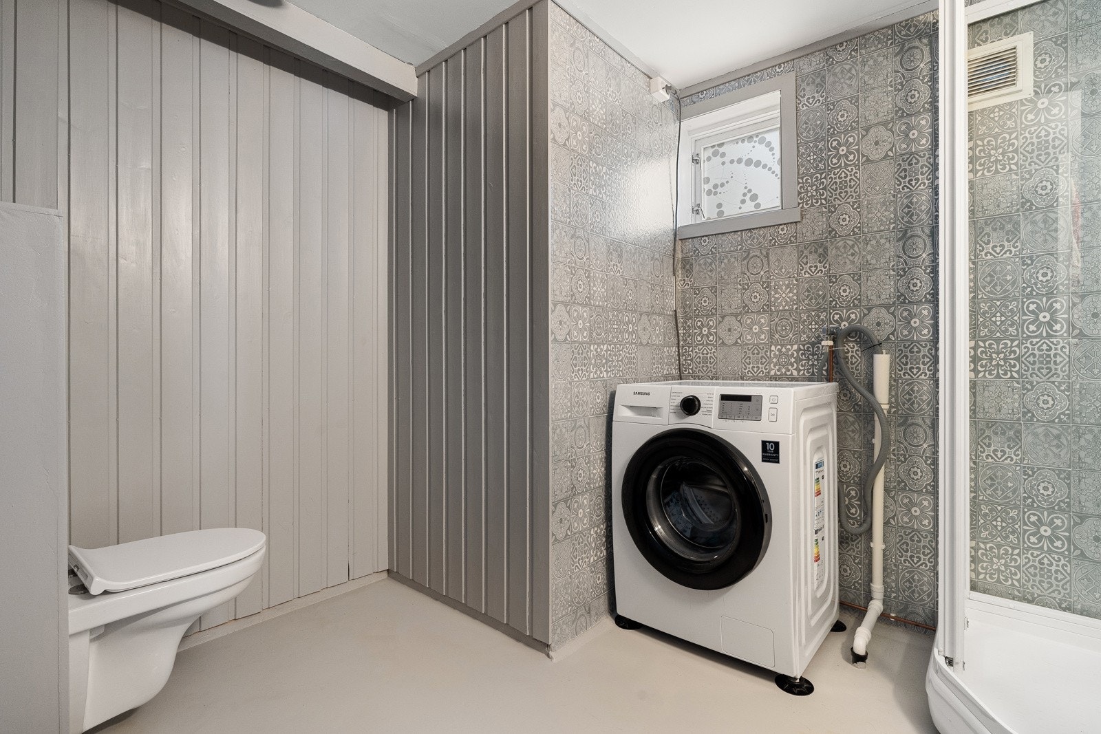 Badet har vegghengt wc og opplegg for vaskemaskin. Galleribilde