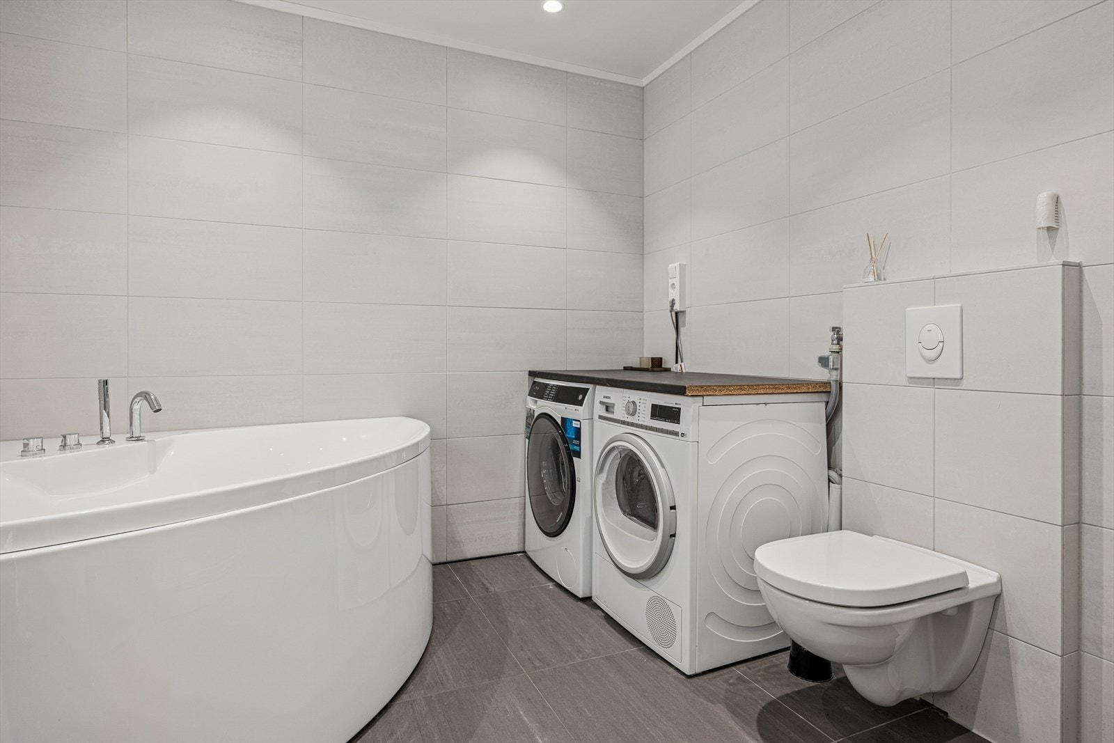 Pent bad/vaskerom med opplegg for vaskemaskin/tørketrommel samt vegghengt toalett. Galleribilde