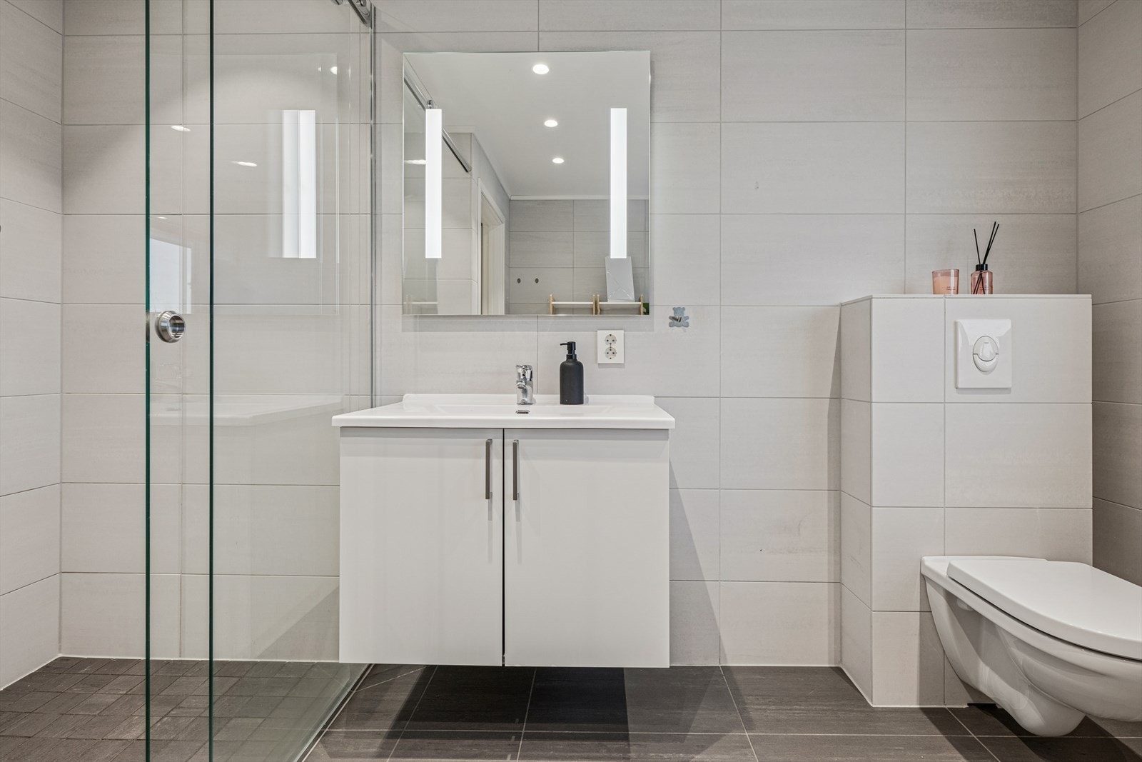 Delikat flislagt bad i boligens første etasje. Galleribilde