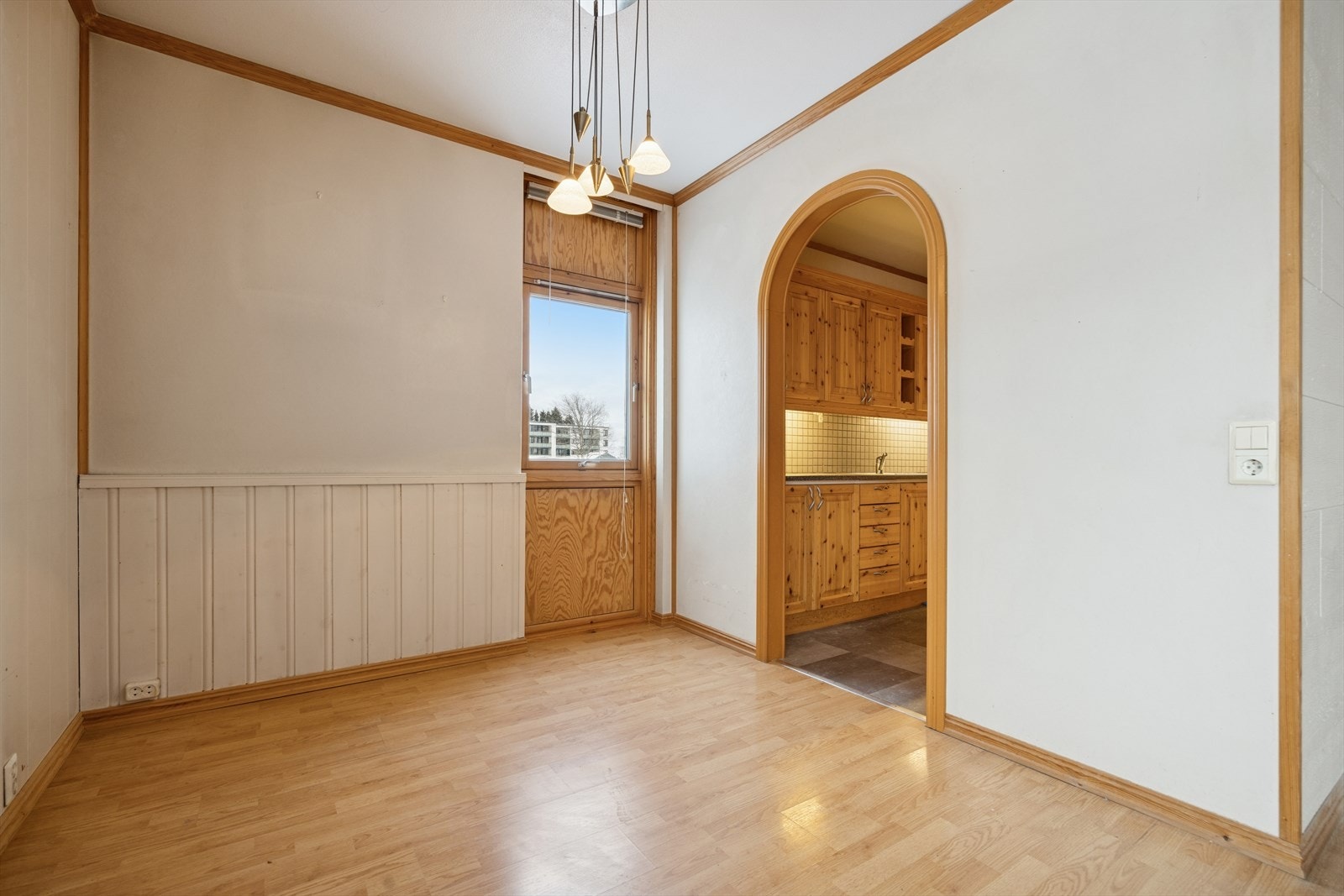 En bueåpning skaper en fin avgrensning mellom stuen og kjøkkenet. Galleribilde