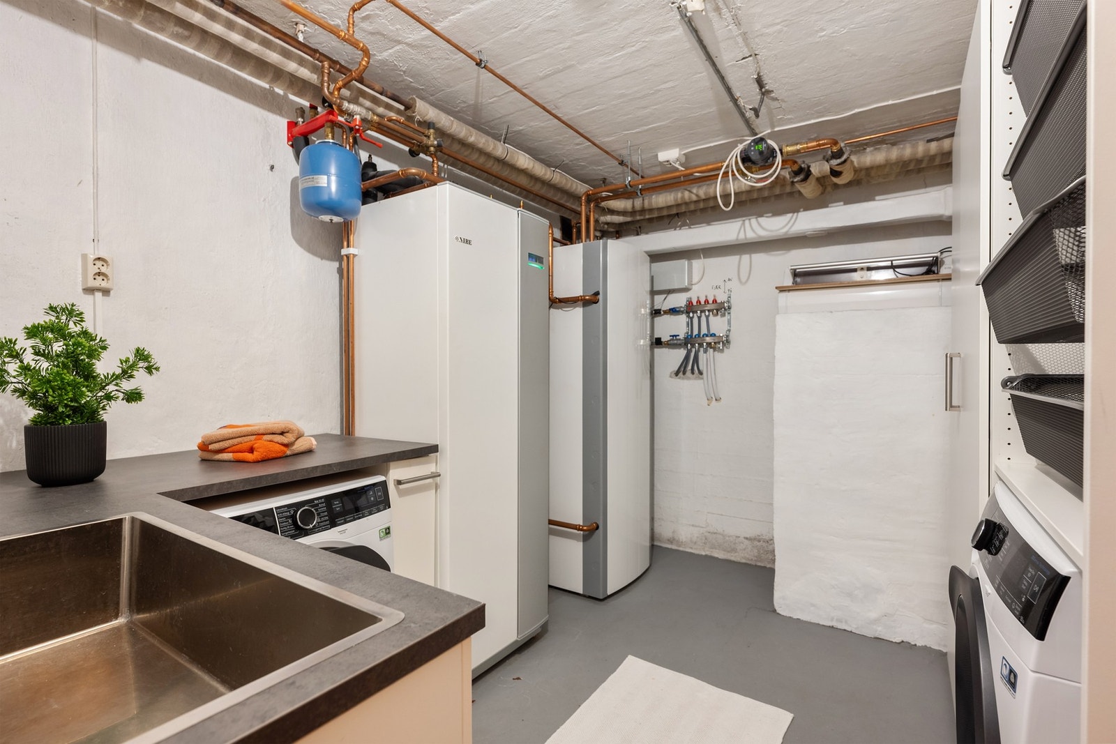 Stort vaskerom som også huser boligens effektive Nibe jordvarmepumpe. Galleribilde