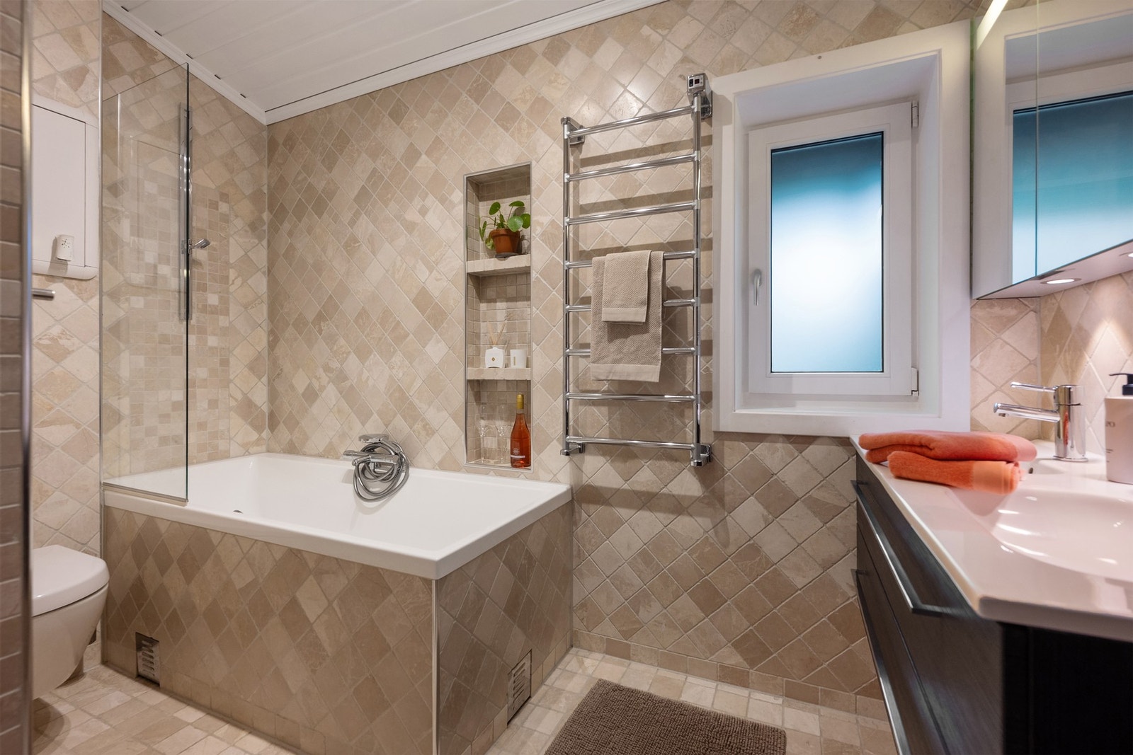 Hovedbad: Innflisede badekaret med praktiske hyller. Galleribilde