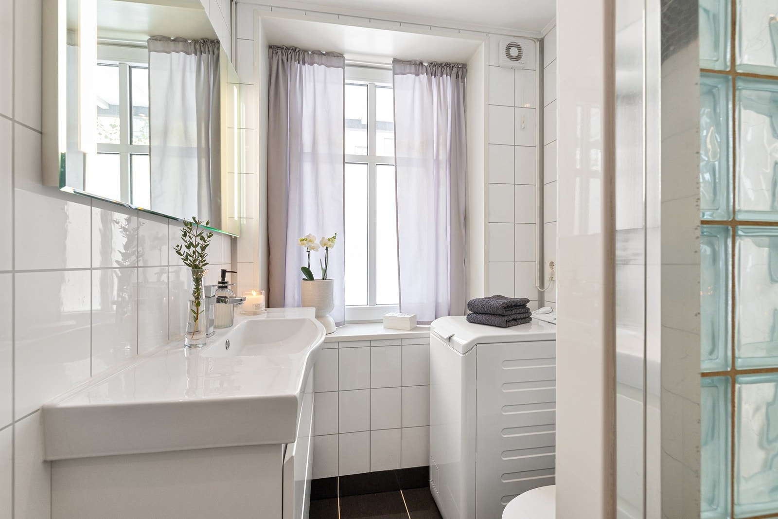 Lyst baderom med baderomsplater på vegger, og flislagte gulv med elektrisk gulvvarme. Galleribilde