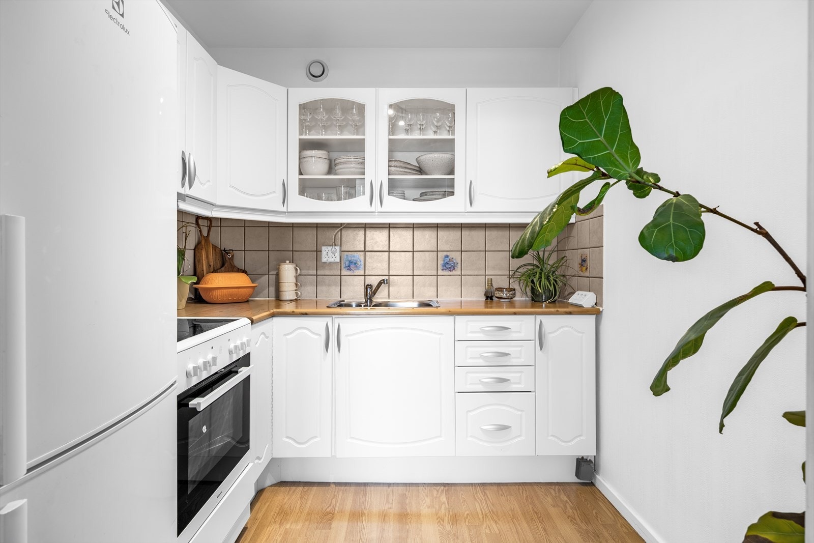 Kjøkkeninnredningen består av under-/overskap og profilerte fronter. Benkeplatene er av laminat med nedfelt kum i rustfritt stål og ett-greps blandebatteri. Galleribilde