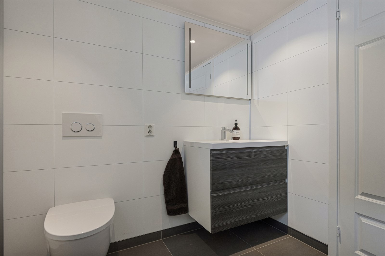 Bad/vaskerom fra 2015 med dusj, vegghengt wc, servant og opplegg for vaskemaskin. Galleribilde