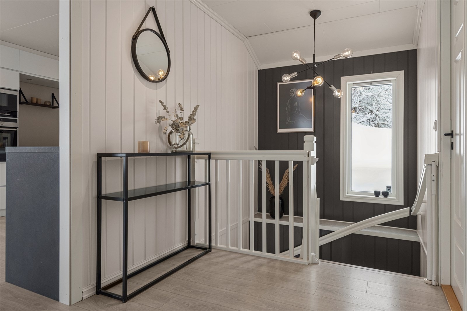 Trappeløp med vindu som sprer dagslys mellom etasjene og skaper åpen romfølelse. Galleribilde