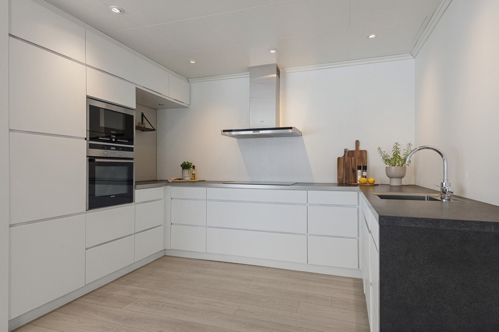 Moderne kjøkken fra 2013 med slette fronter og integrerte hvitevarer. Galleribilde