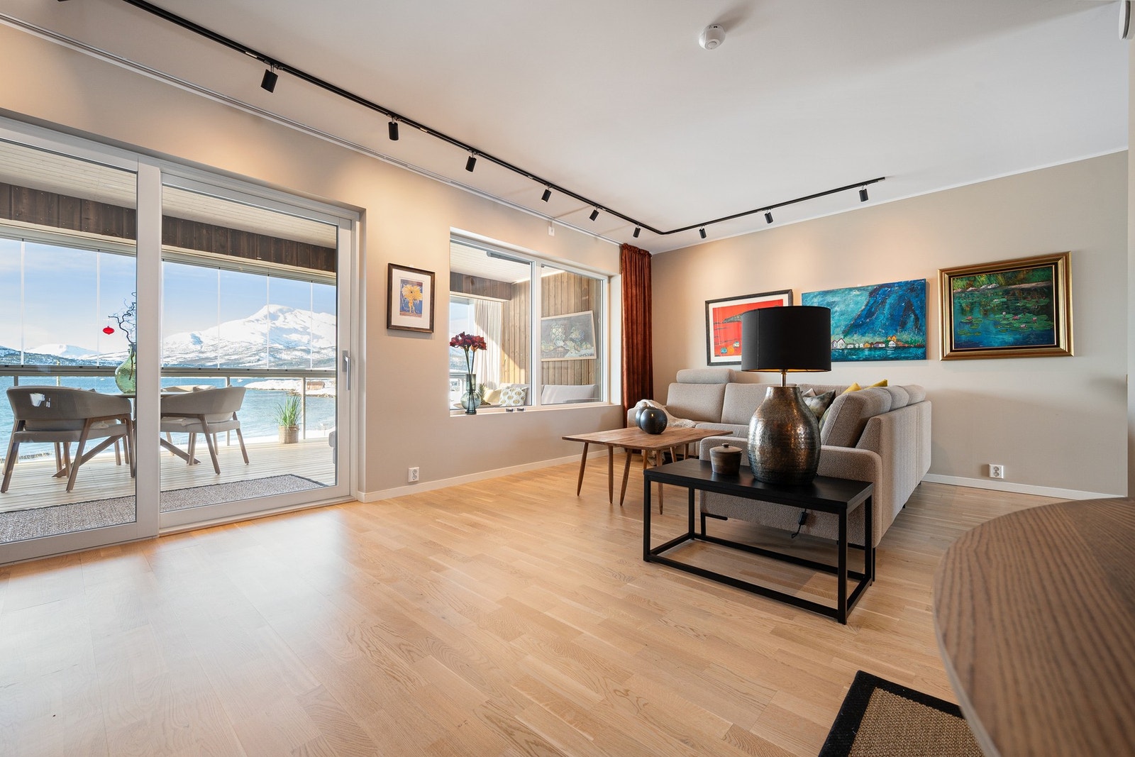 Stua er lys og romslig med godt lysinnslipp fra store vinduer og helglasset balkongdør Galleribilde