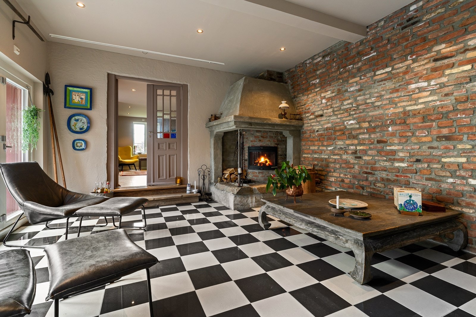 Rålekker stue med god plass til sofagruppe, hvor den originale murveggen møter moderne detaljer som slette vegger. Galleribilde