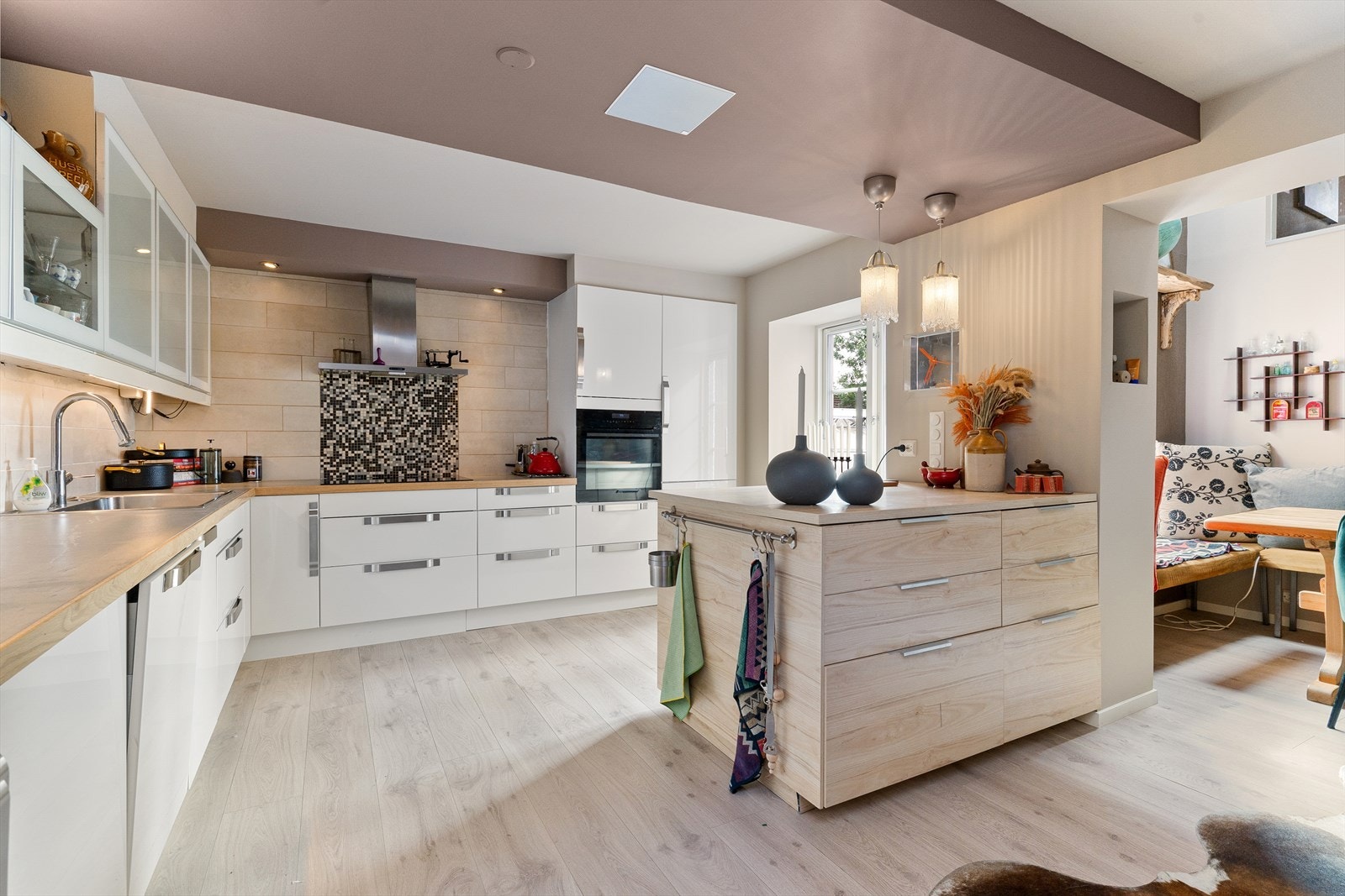 Kjøkkeninnredningen har glatte fronter, laminert og flislagt benkeplate, vaskekum i stål, nedfelt komfyrtopp, ventilator, stekeovn, oppvaskmaskin, kjøl/frys, vinskap. Galleribilde