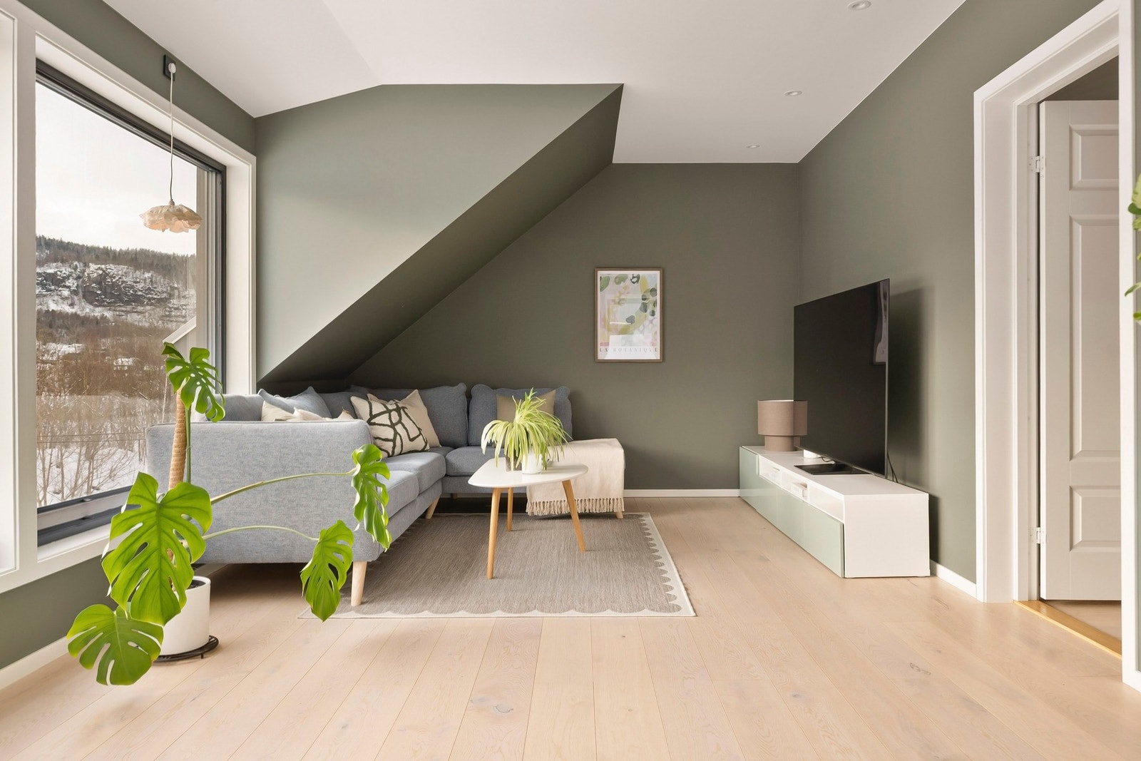 Gulvene er belagt med eikeparkett og veggene er malt i en mørk grønntone. Galleribilde