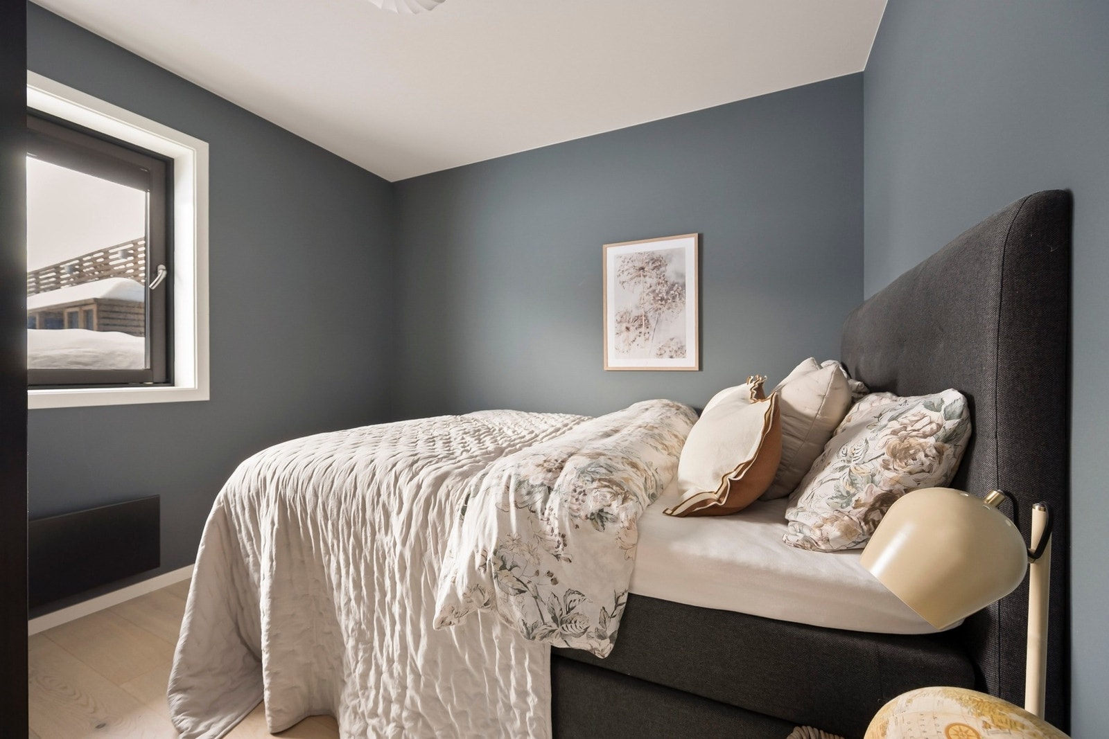 Soverommet har malte vegger i en mørk blåtone og eikeparkett på gulv, noe som skaper en rolig og innbydende atmosfære.. Galleribilde