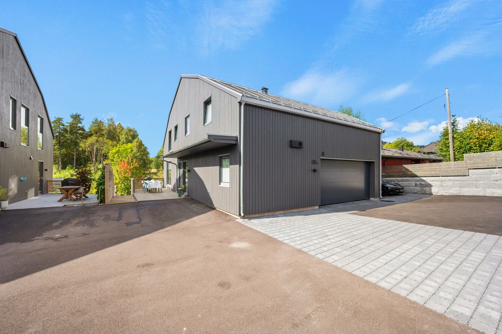 Boligen har en stor gårdsplass som er pent opparbeidet med asfalt og heller. Galleribilde