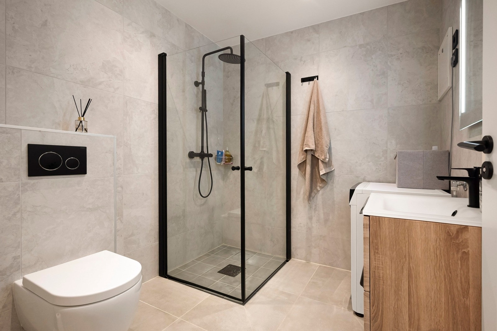 Badet er pent og tidsriktig utført med flislagte overflater, behagelig gulvvarme og opplegg for vaskemaskin. Galleribilde