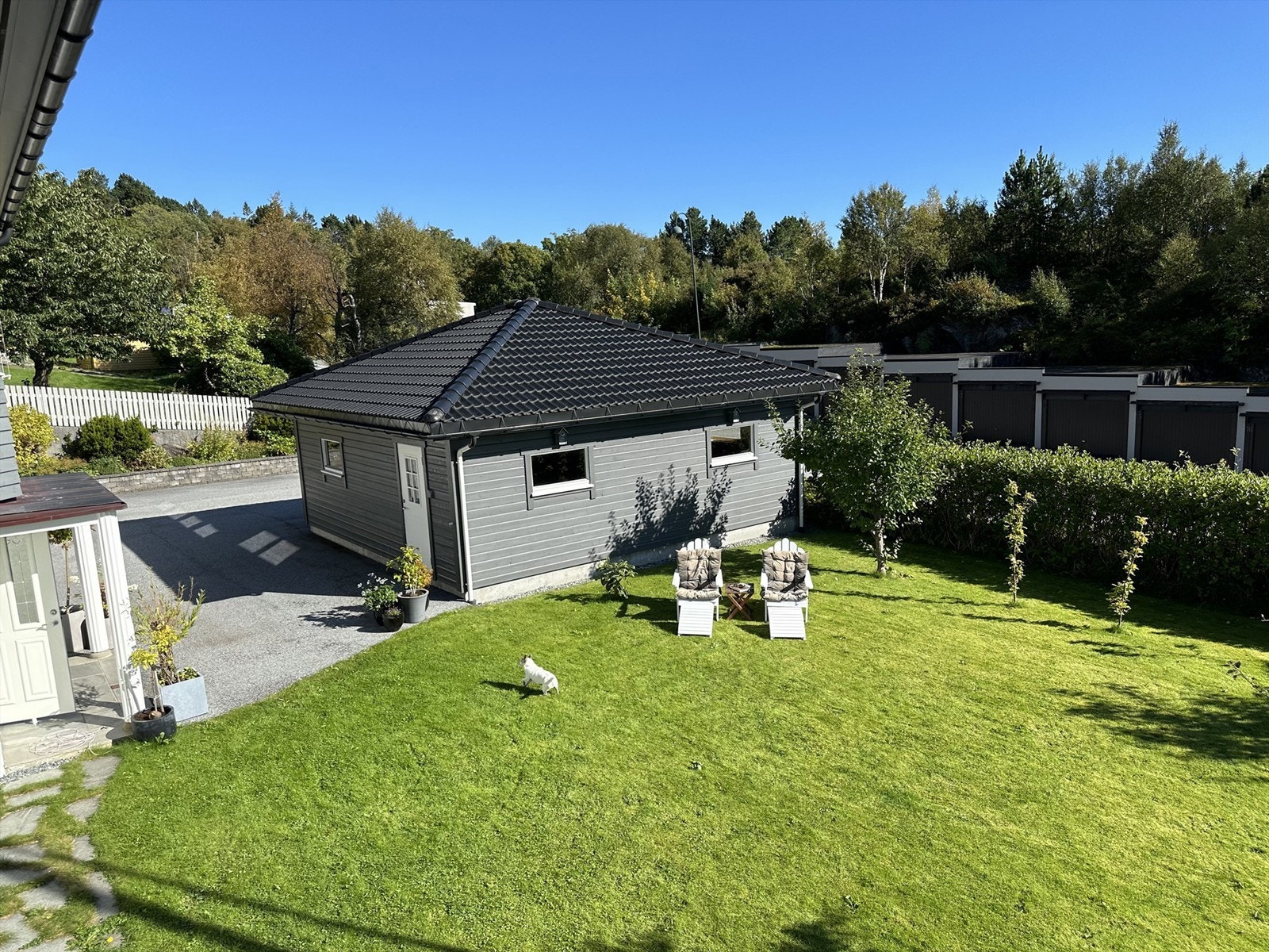 Skjermet hage med plen og beplantinger - bilde tatt fra terrassen av selger sommerstid Galleribilde