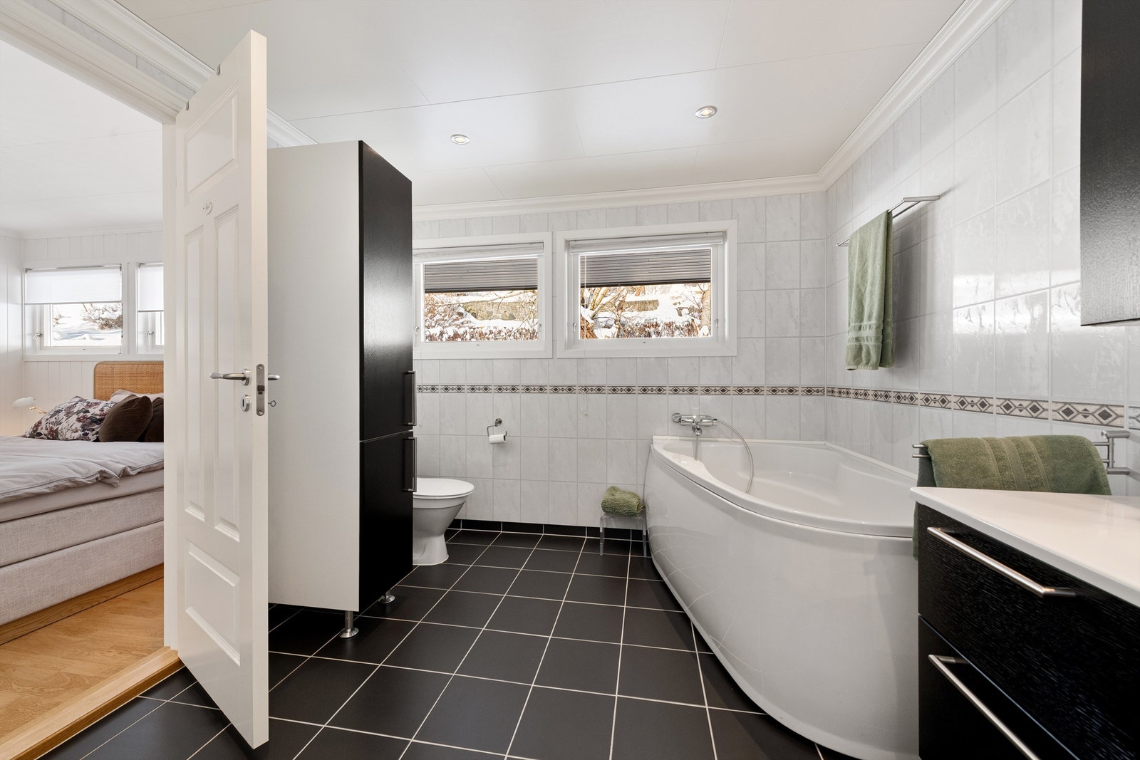 Badet i hovedetasjen har hjørnebadekar, dusjkabinett og gulvstående toalett Galleribilde