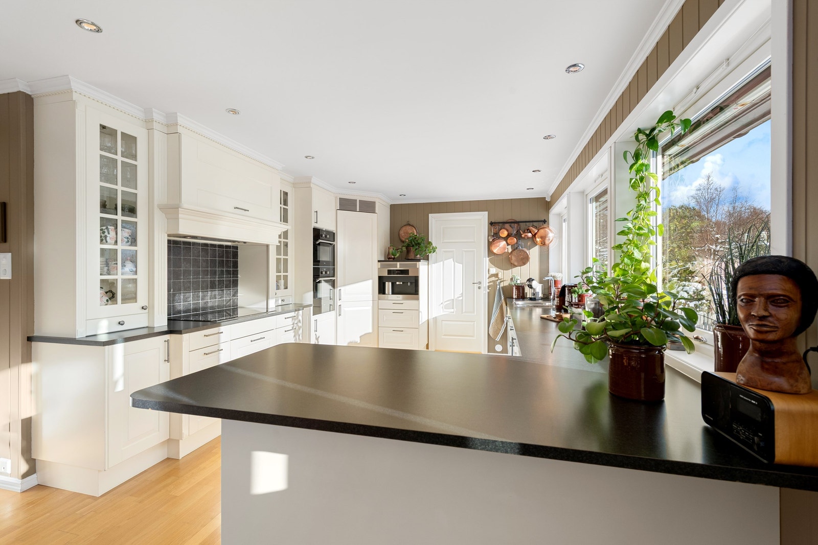 Kjøkkeninnredning med hvite profilerte fronter og benkeplate av laminat Galleribilde