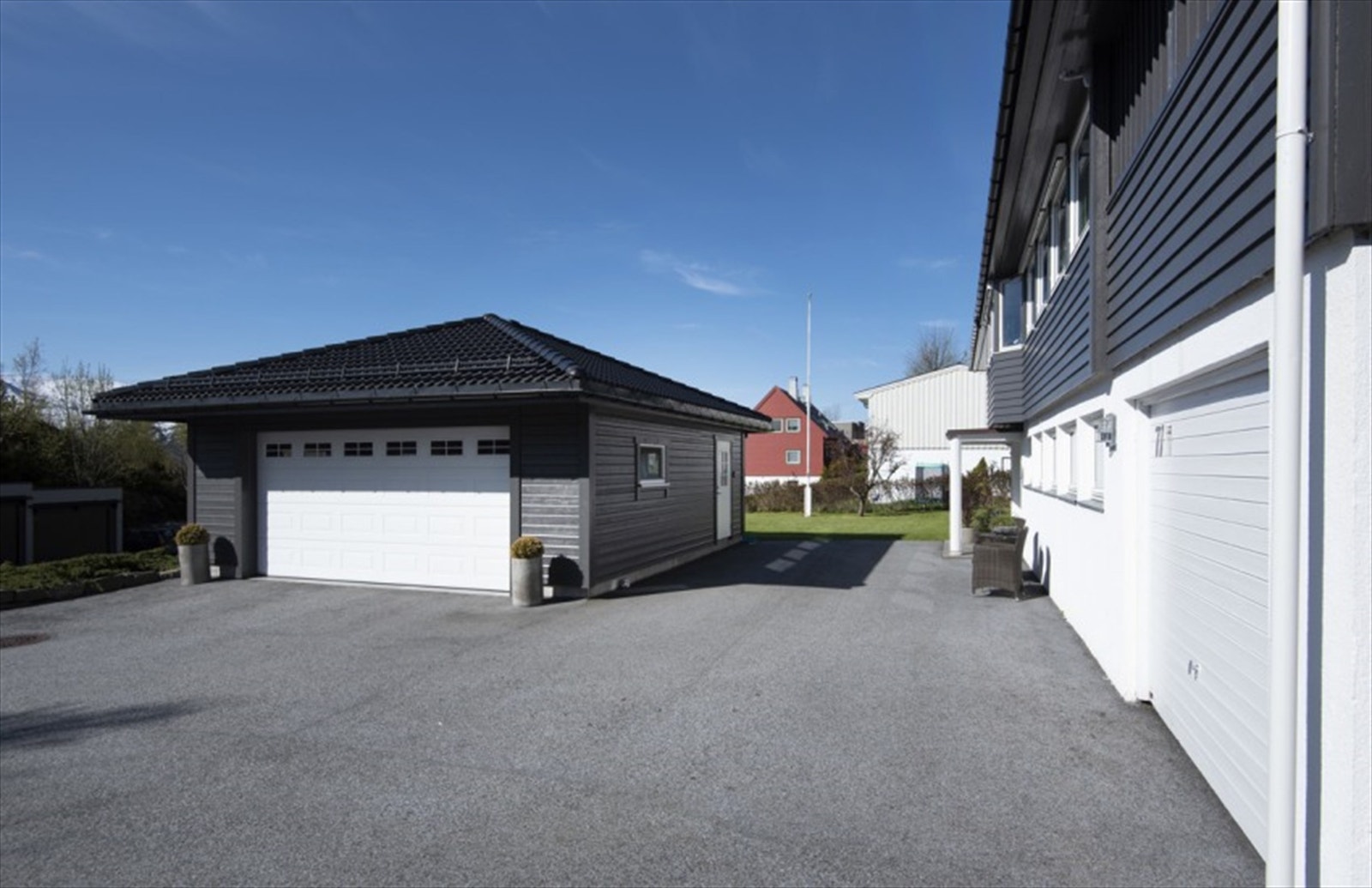 Garasje og stort asfaltert parkeringsareal Galleribilde