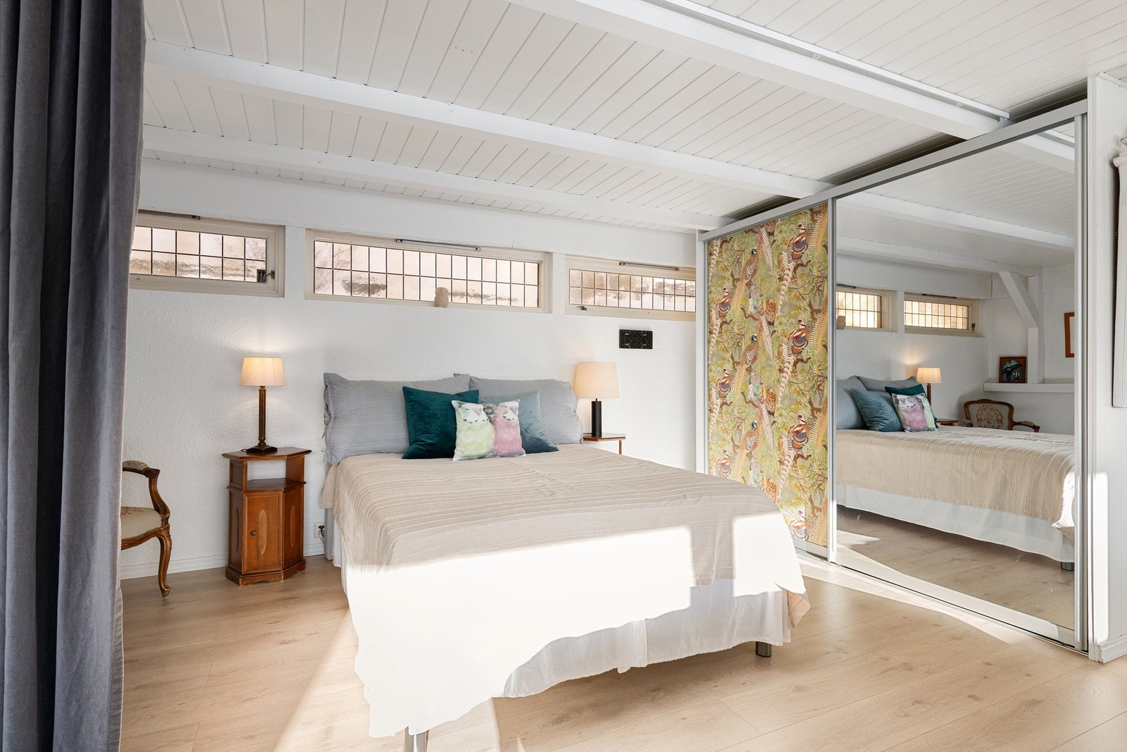 Deler av kjellerstuen er avdelt med gardin og benyttes som soverom. Her er det montert skyvedørsgarderobe med 2 dører, hvorav 1 speildør Galleribilde