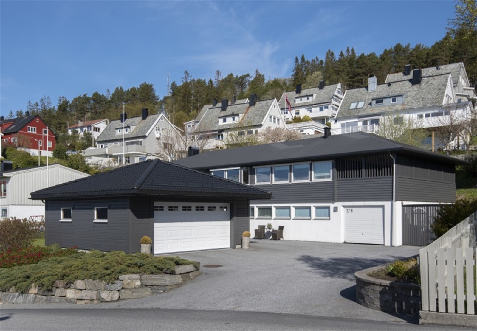 Fasade, garasje og asfaltert parkeringsareal Galleribilde