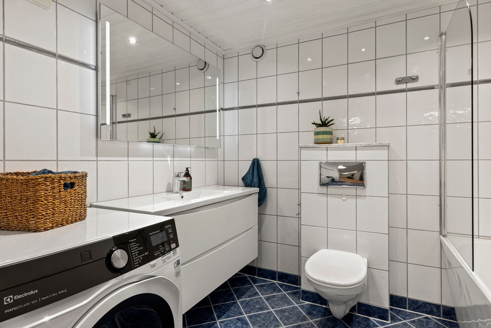 Badet har flislagte vegger og gulv, samt panel i himlingen Galleribilde