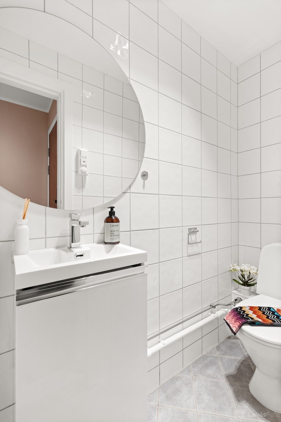 Separat toalettrom med flislagte flater, innredet med servant med underskap til oppbevaring og toalett. Inngang fra entrè. Galleribilde