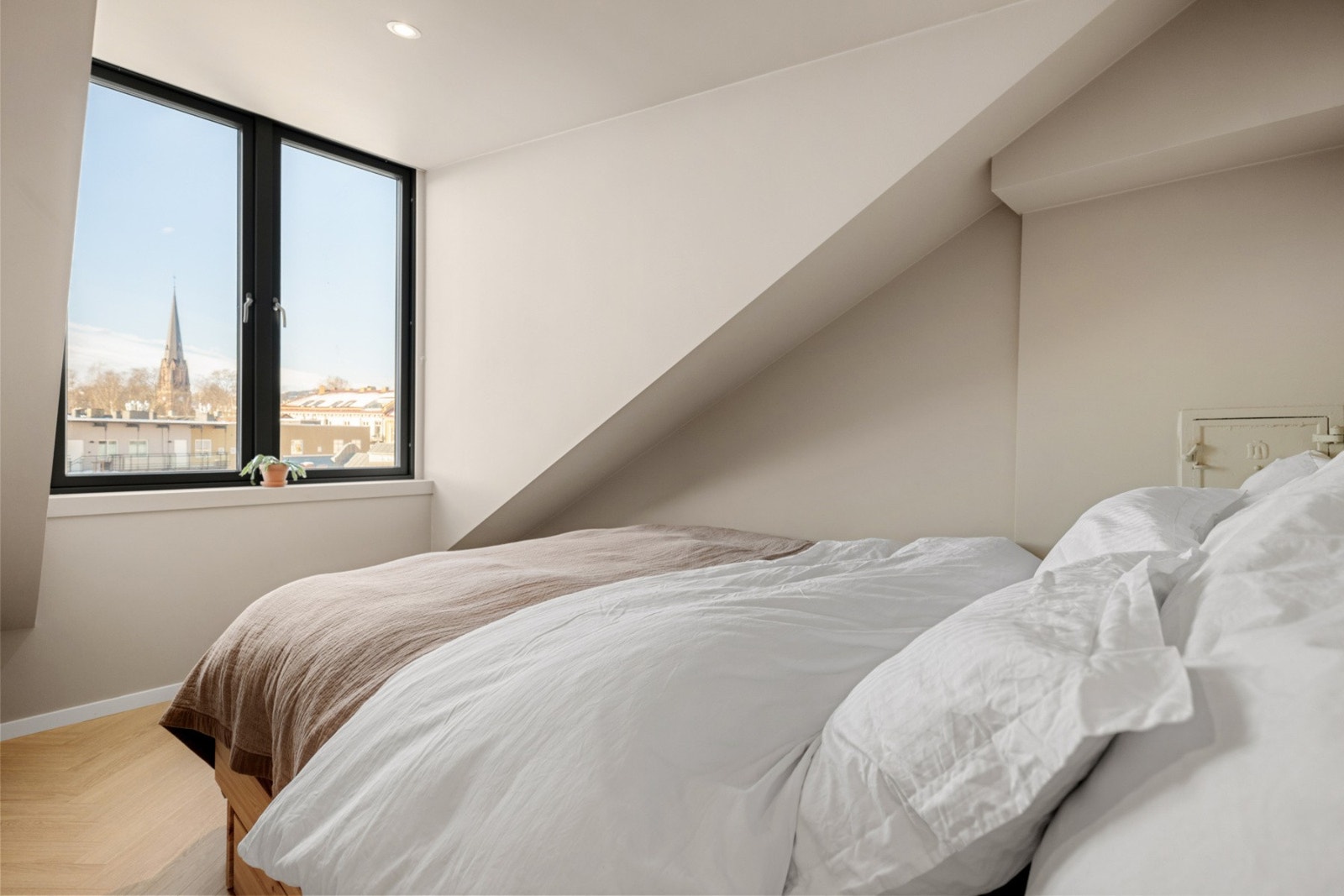 Her får man følelsen av å våkne med utsyn over byen og takene. Spiret på Birkelunden kirke er det eneste som titter opp fra sengekanten. Galleribilde
