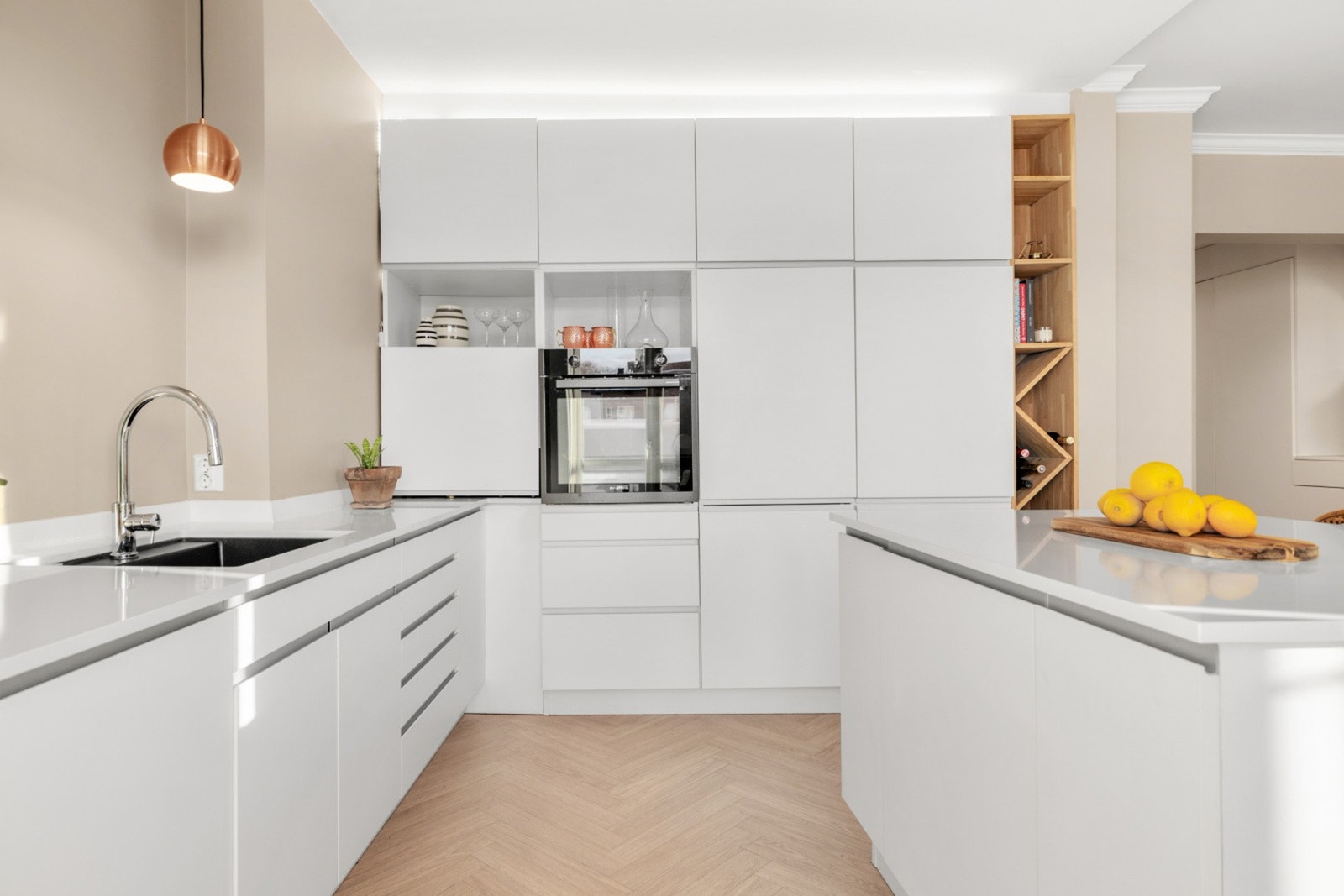 Innredningen har glatte, laminerte fronter og kompositt benkeplate med underliggende oppvaskkum. Galleribilde