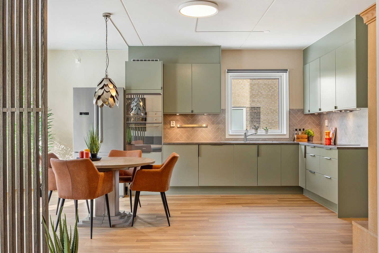 Stilrent kjøkken fra 2022 i en åpen og innbydende stue- og kjøkkenløsning. Galleribilde