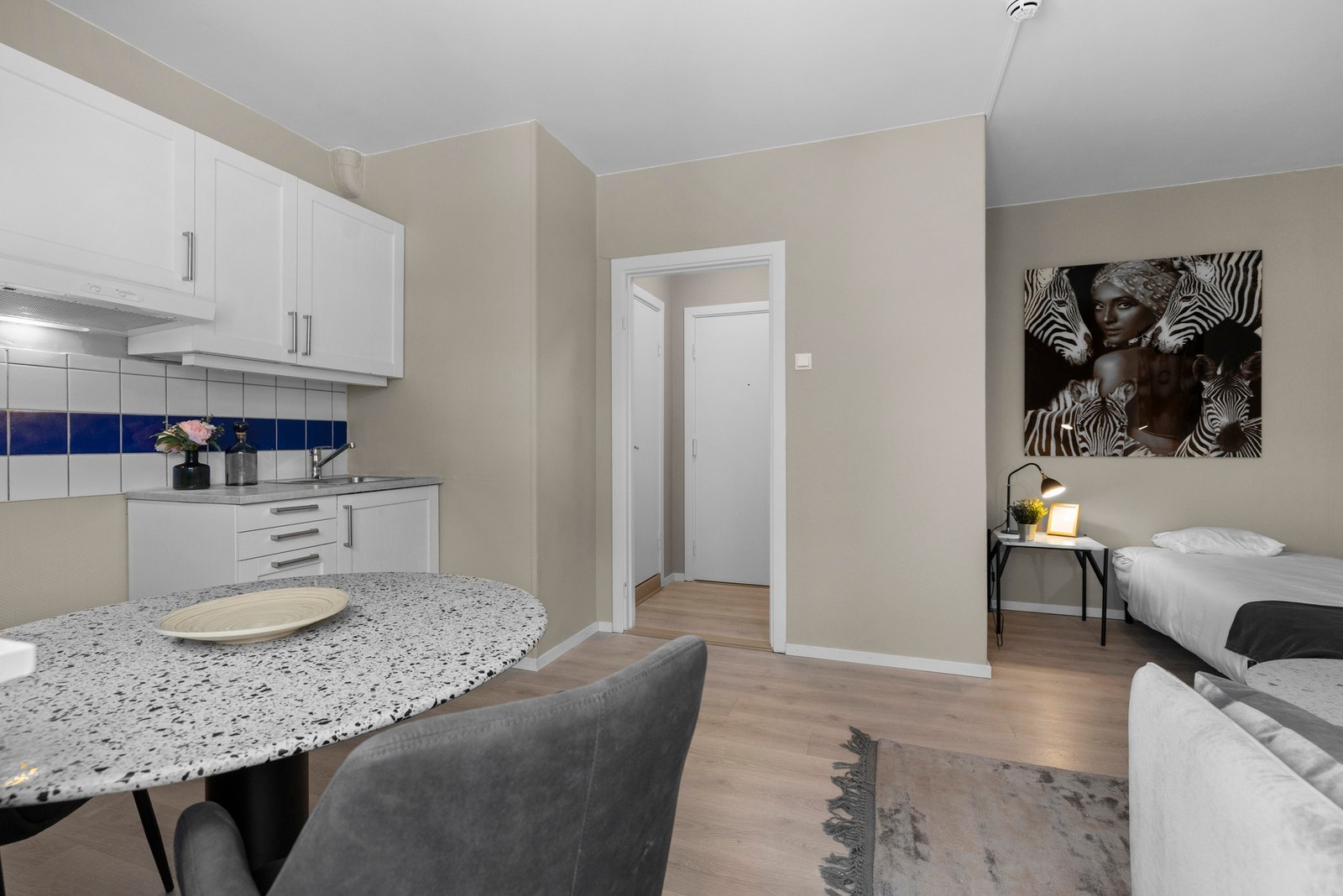 Tidsriktig gulv og veggflater i delikate fargetoner. Det er mulig å sette opp lettvegg i stue for å etablere en adskilt sovealkove. Galleribilde