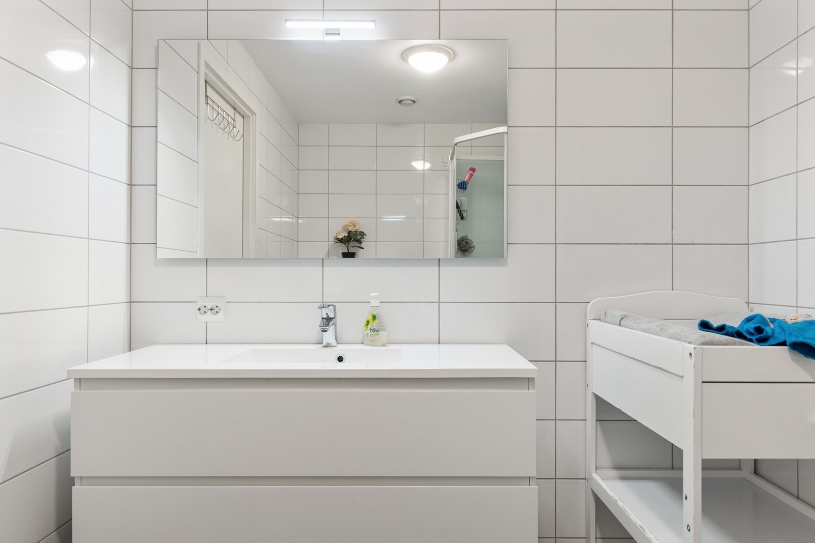 Det er dusjkabinett, og badet har et pent og romslig baderomsmøblement, speil med integrert belysning og vegghengt WC. Galleribilde