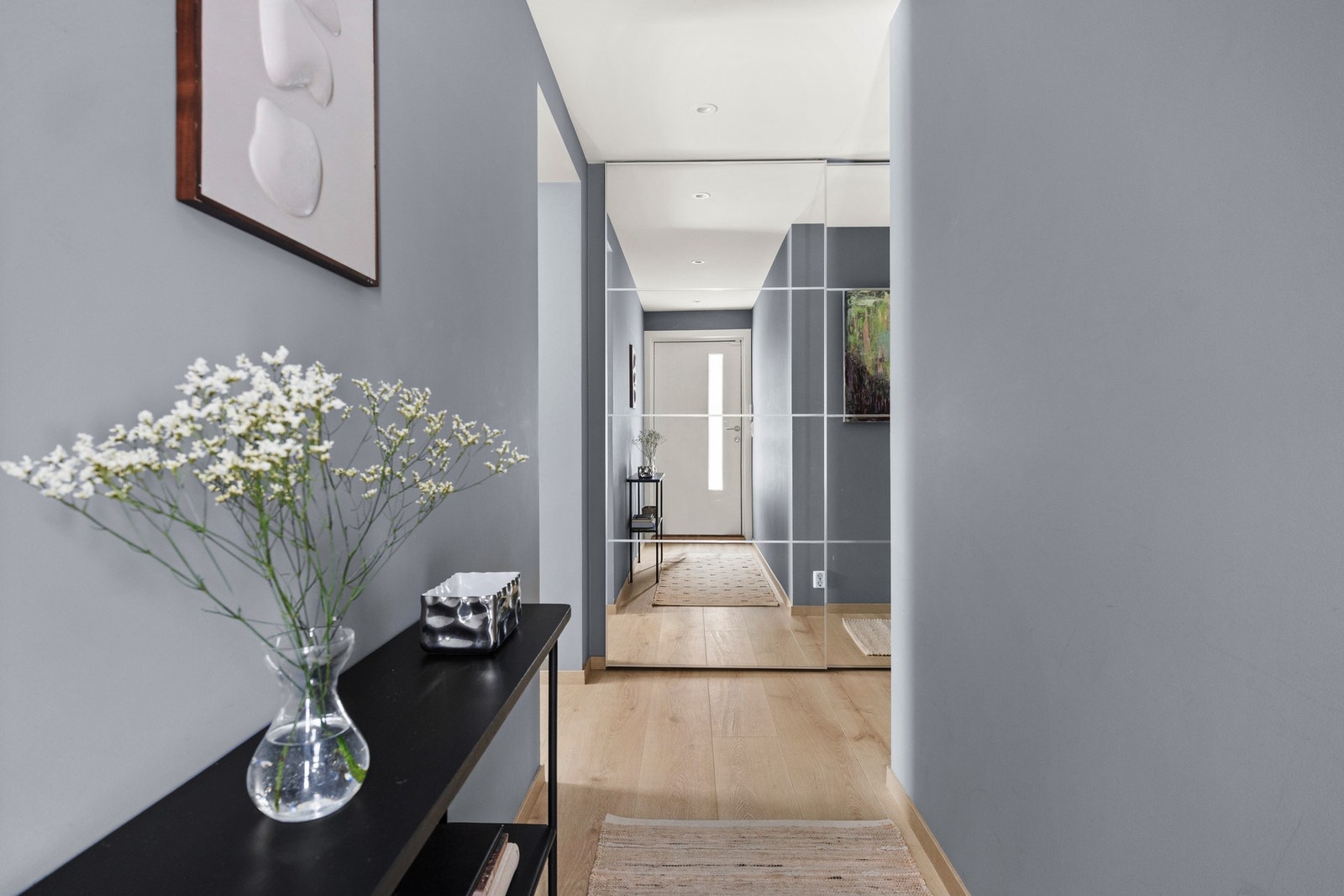 Hyggelig entré malt i en dus blå-farge med plass til yttertøy i skaprekke. Galleribilde