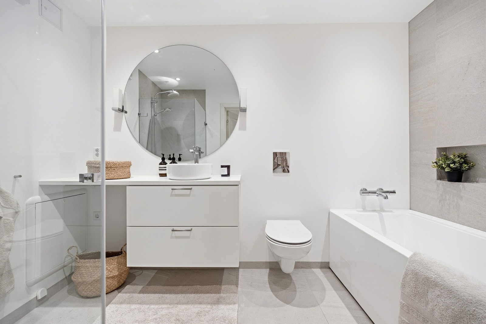 Lekkert baderom fra 2021/2022. Badet er utstyrt med vegghengt toalett, innredning med toppmontert servant, badekar og dusjhjørne. Galleribilde