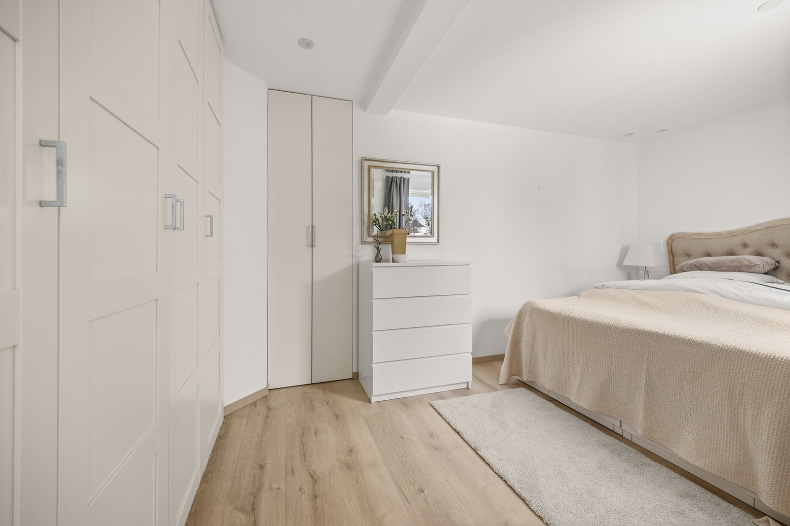 Romslig soverom på ca. 13 kvm med plass til dobbeltseng, tilhørende nattbord og garderobeskap langs kortsiden av rommet. Galleribilde
