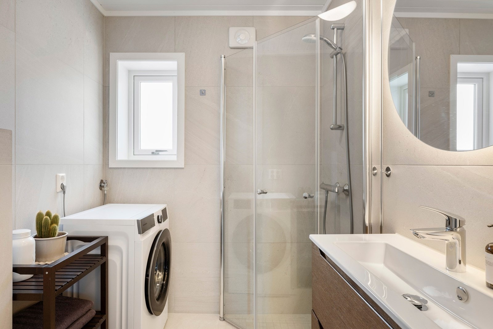 Moderne bad totalrenovert i 2023. Flislagte gulv og vegger, og innredet med nedfelt servant, vegghengt toalett, dusj og opplegg for vaskemaskin. Galleribilde