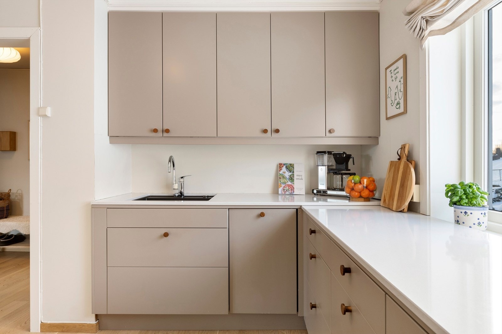 Kjøkkeninnredning med glatte fronter, og benkeplate av stein som gir et eksklusivt uttrykk. Galleribilde