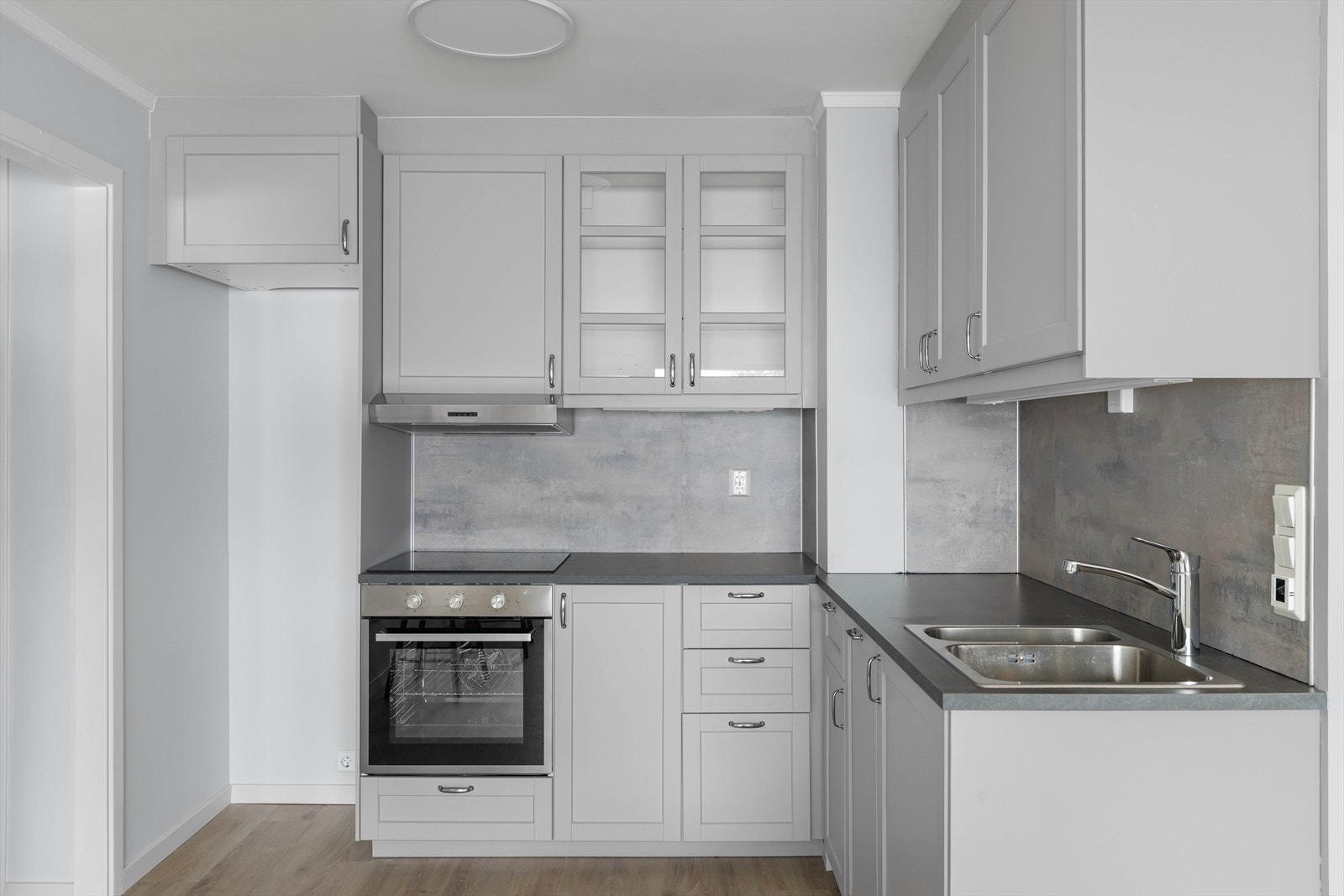 Det er plass for kjøleskap og det er integrerte hvitevarer som oppvaskmaskin, induksjonstopp, stekeovn samt vannstoppsystem Galleribilde