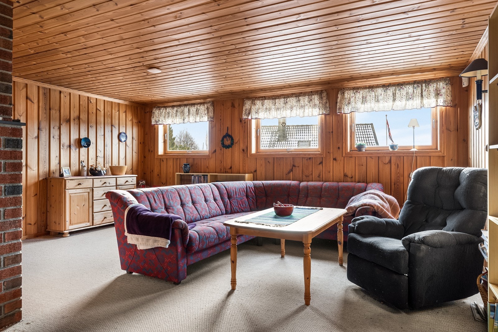 Kjelleren rommer en stor stue med panel på vegger og tak, ideell som TV-stue. Kjellerstuen er ikke godkjent for varig opphold. Galleribilde