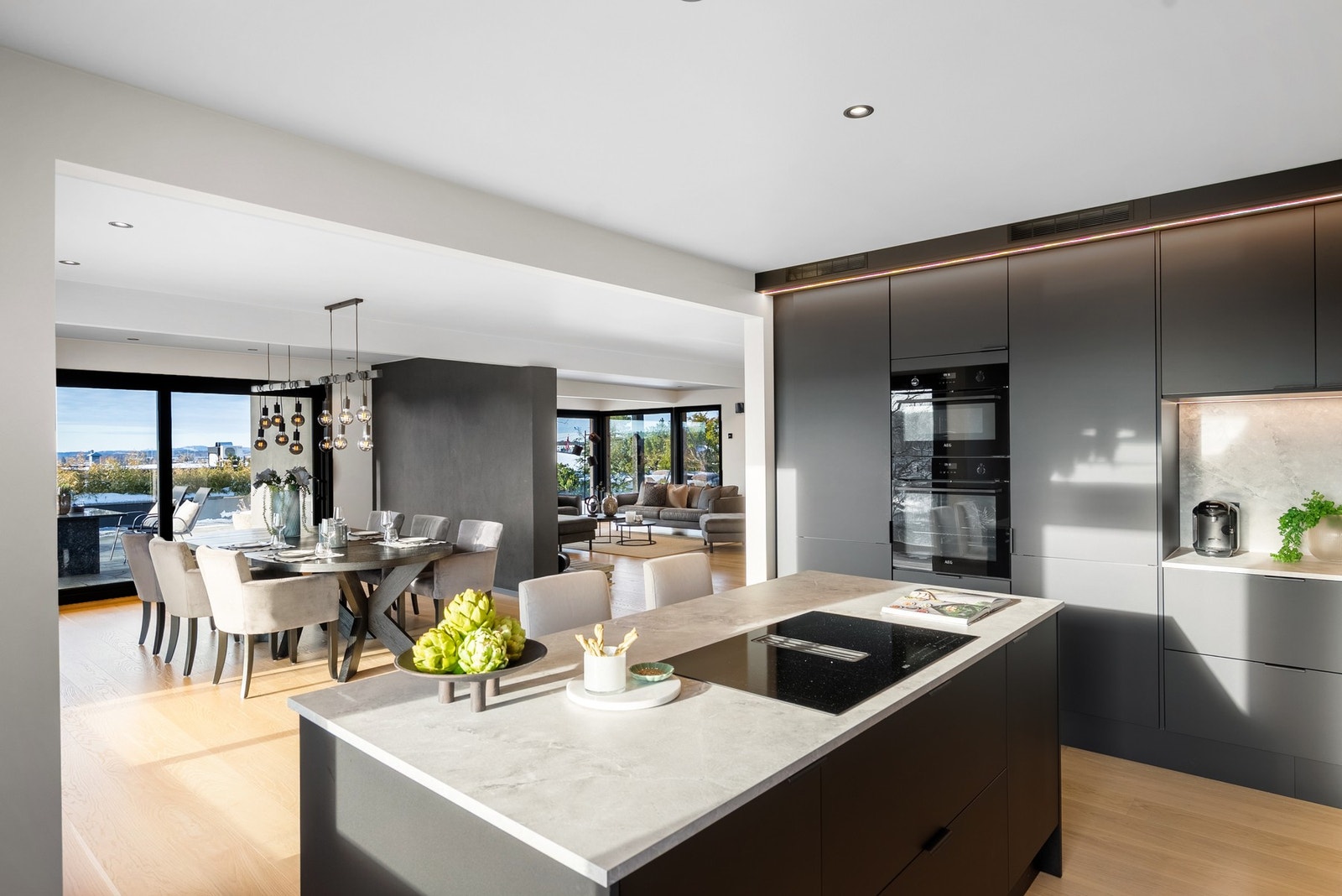 Kjøkkenøyen gjør at det åpne rommet bevares og kokken kan delta i det sosiale rommet Galleribilde