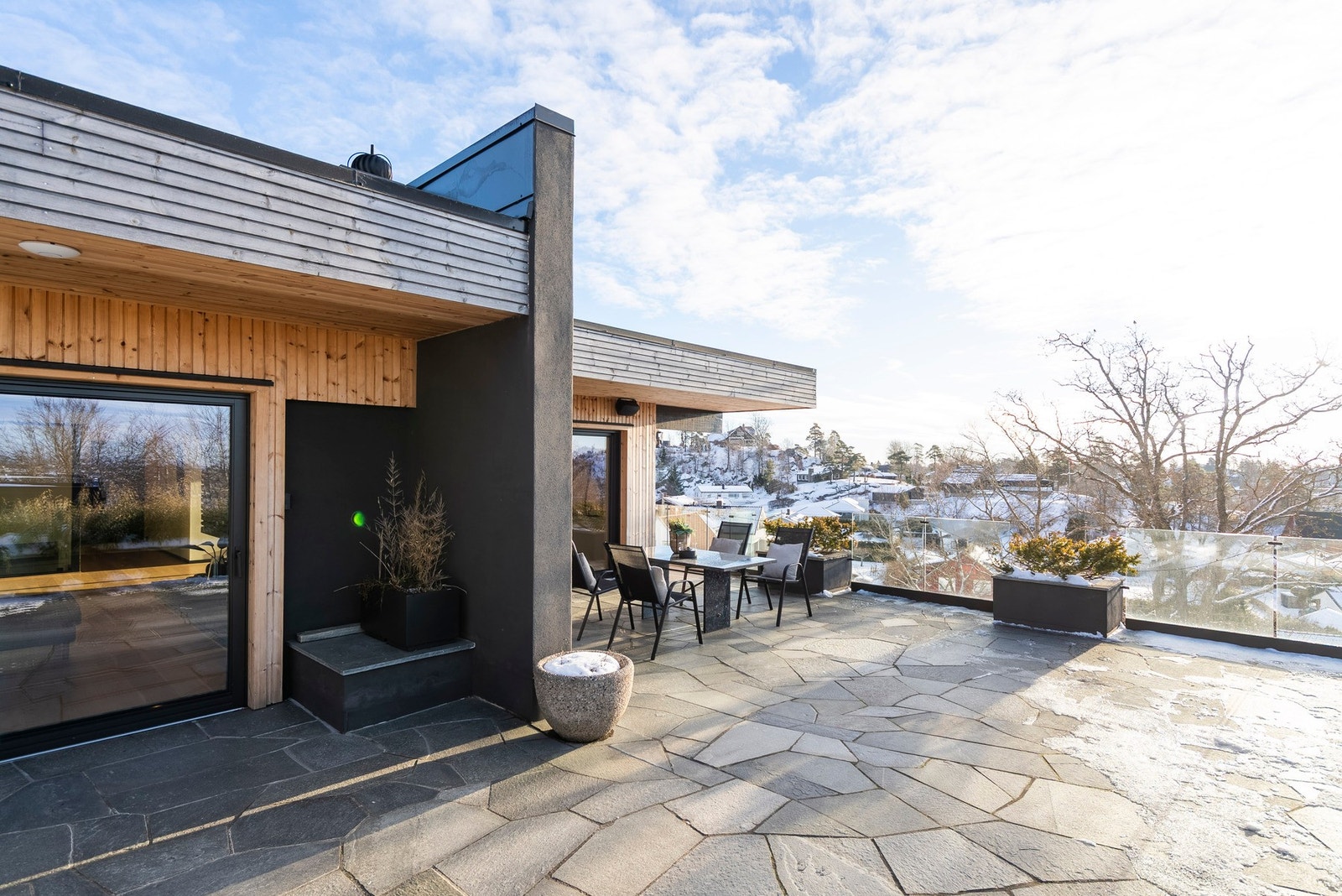 Her glir boligen naturlig inn i terrenget og omgivelsene, med en romslig terrasse som gir god plass til flere sittegrupper - perfekt å nyte gjennom hele året og ved enhver anledning Galleribilde