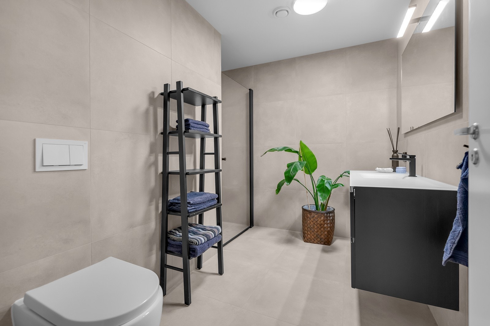 Lekkert bad med toalett, servant med skuffer og dusjhjørne. Galleribilde