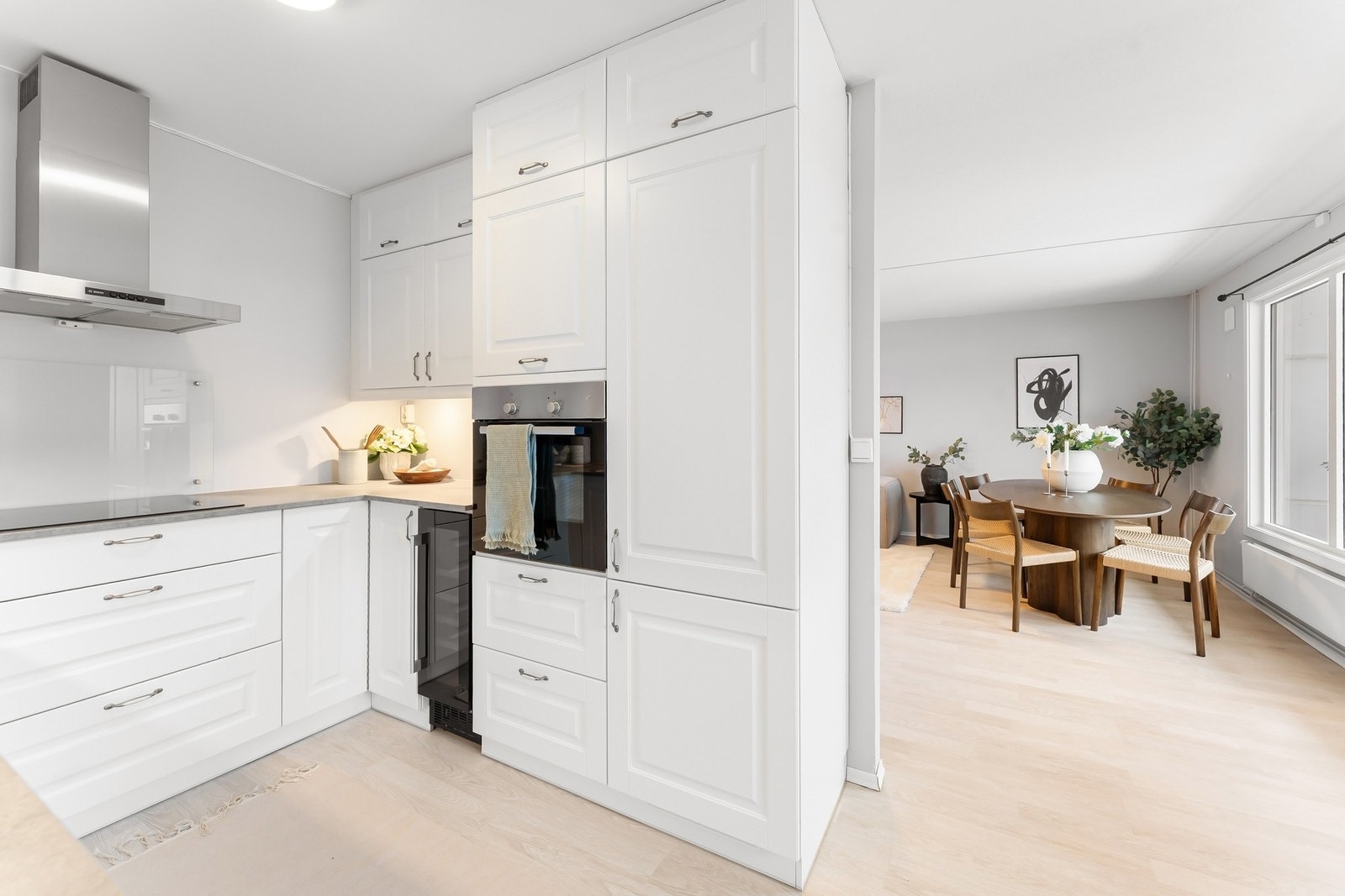 Integrerte hvitevarer med induksjonsplatetopp, stekeovn, oppvaskmaskin, kjøle/fryseskap og vinskap. Galleribilde