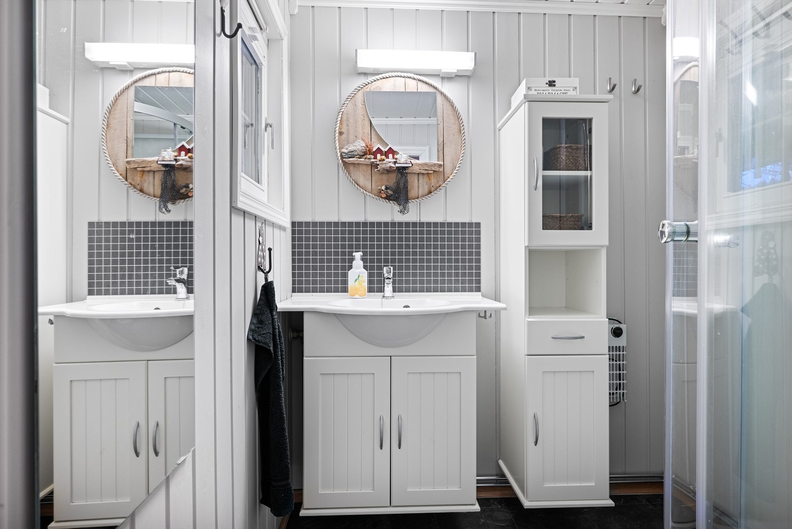 Badet er innredet med servantskap med heldekkende servant, høyskap og dusjkabinett. Galleribilde